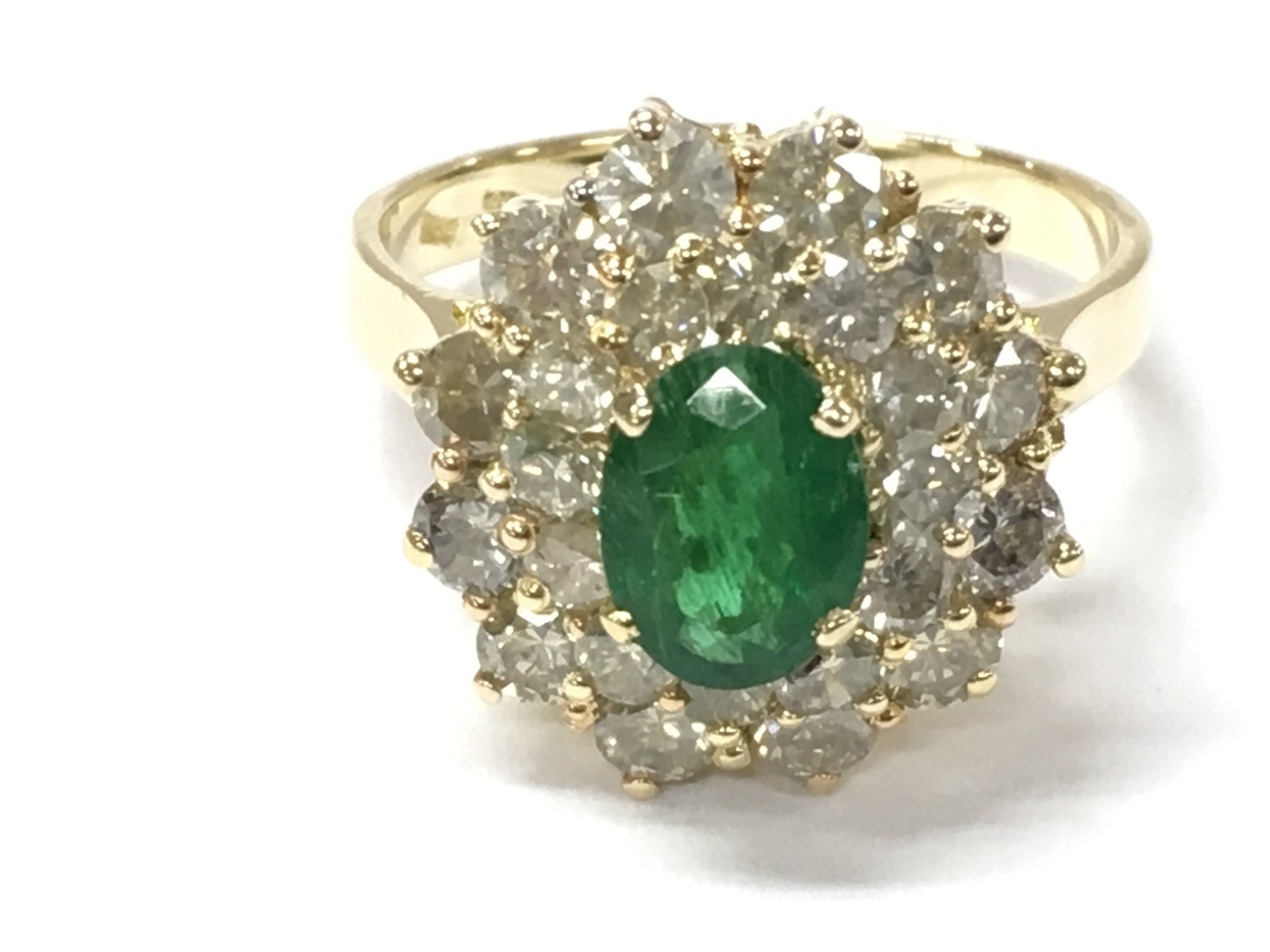 A 14ct gold oval emerald and round cut diamonds in a double halo ring. Emerald 1.05ct and diamond approximately 2.35ct. Size R. Postage B