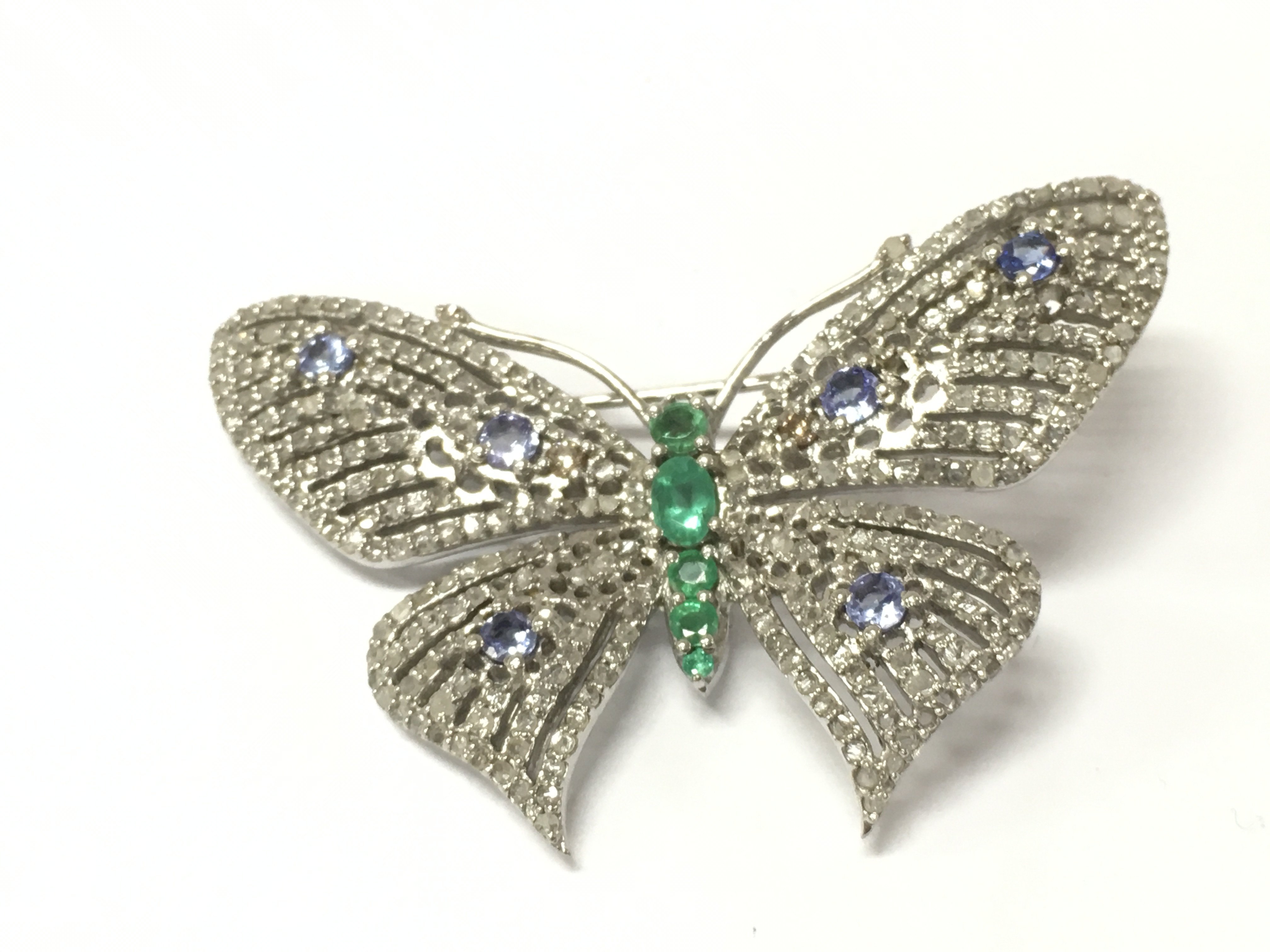 An attractive silver brooch / pendant combined set with Emeralds tanzanite and several diamonds. Emeralds 0.80ct Tanzanite 0.61ct and diamonds 1.86ct approx. Postage B