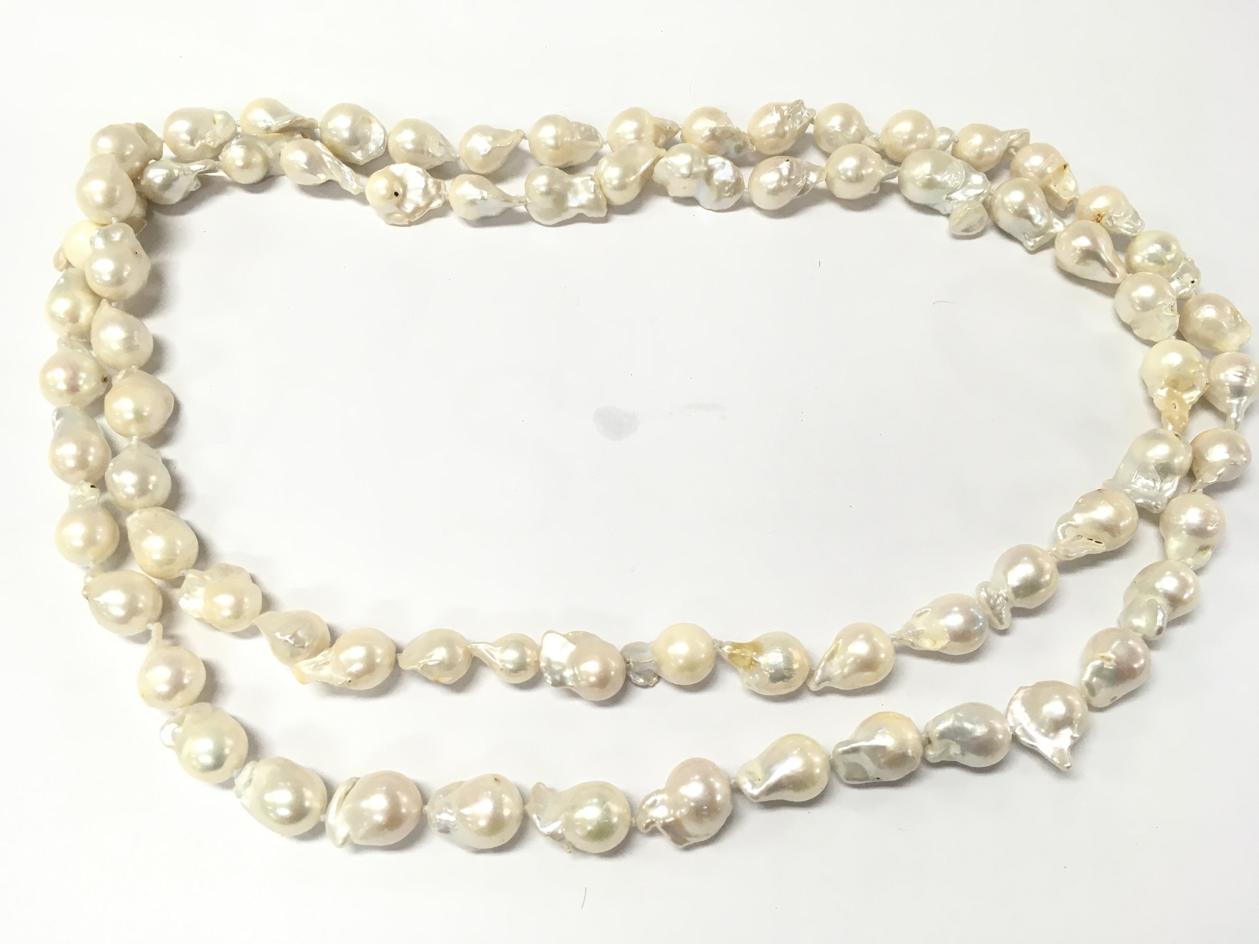 An extra long and weighty string of organic shaped baroque pearls. Approximately 50 inches long so can be worn a single or wrapped round to give the illusion of double strand.