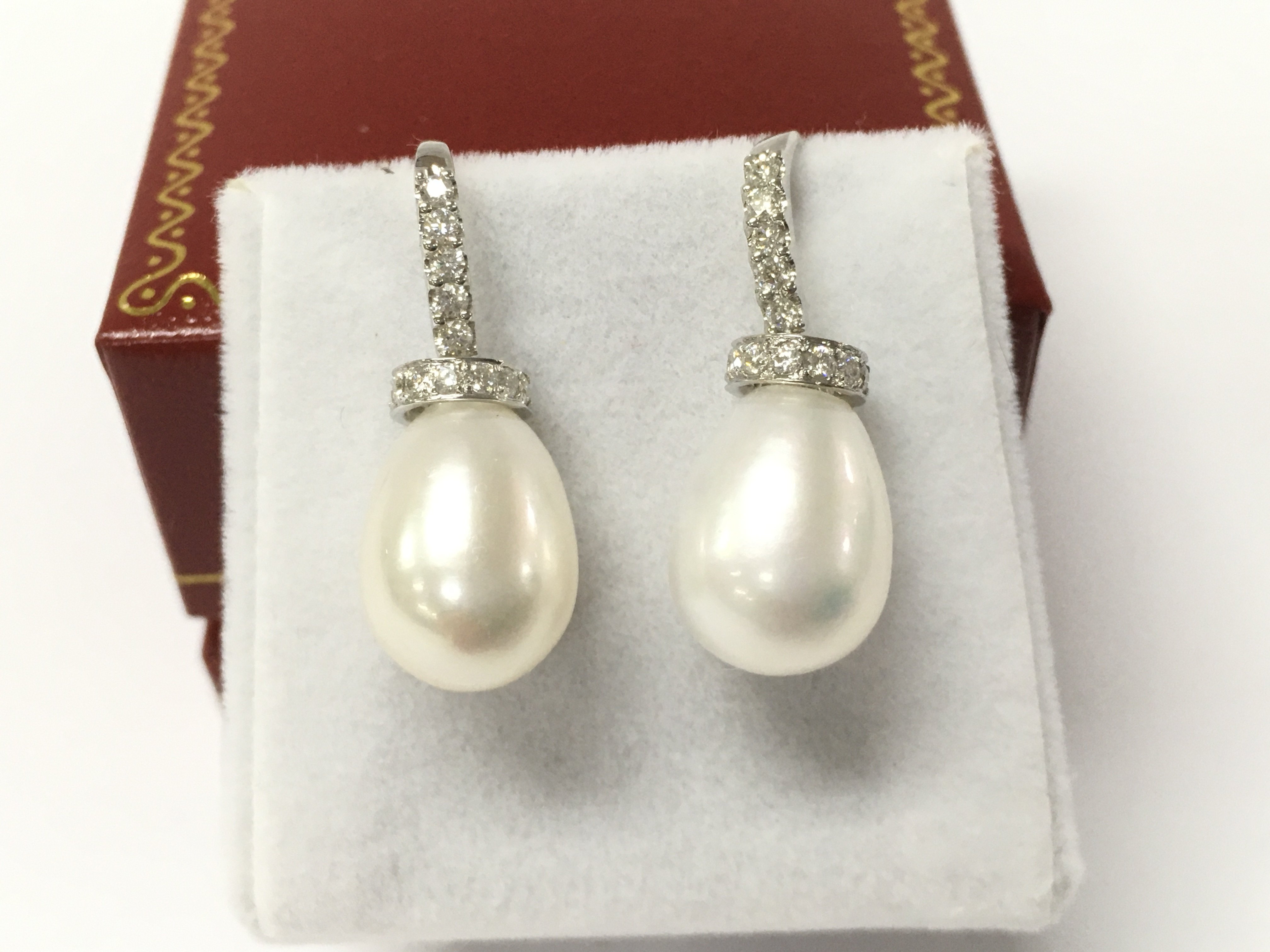 A pair of 18ct white gold bell shaped cultured pearl earrings set with diamonds in the bales and collars with fish hook backs, diamonds approximately 0.40ct.