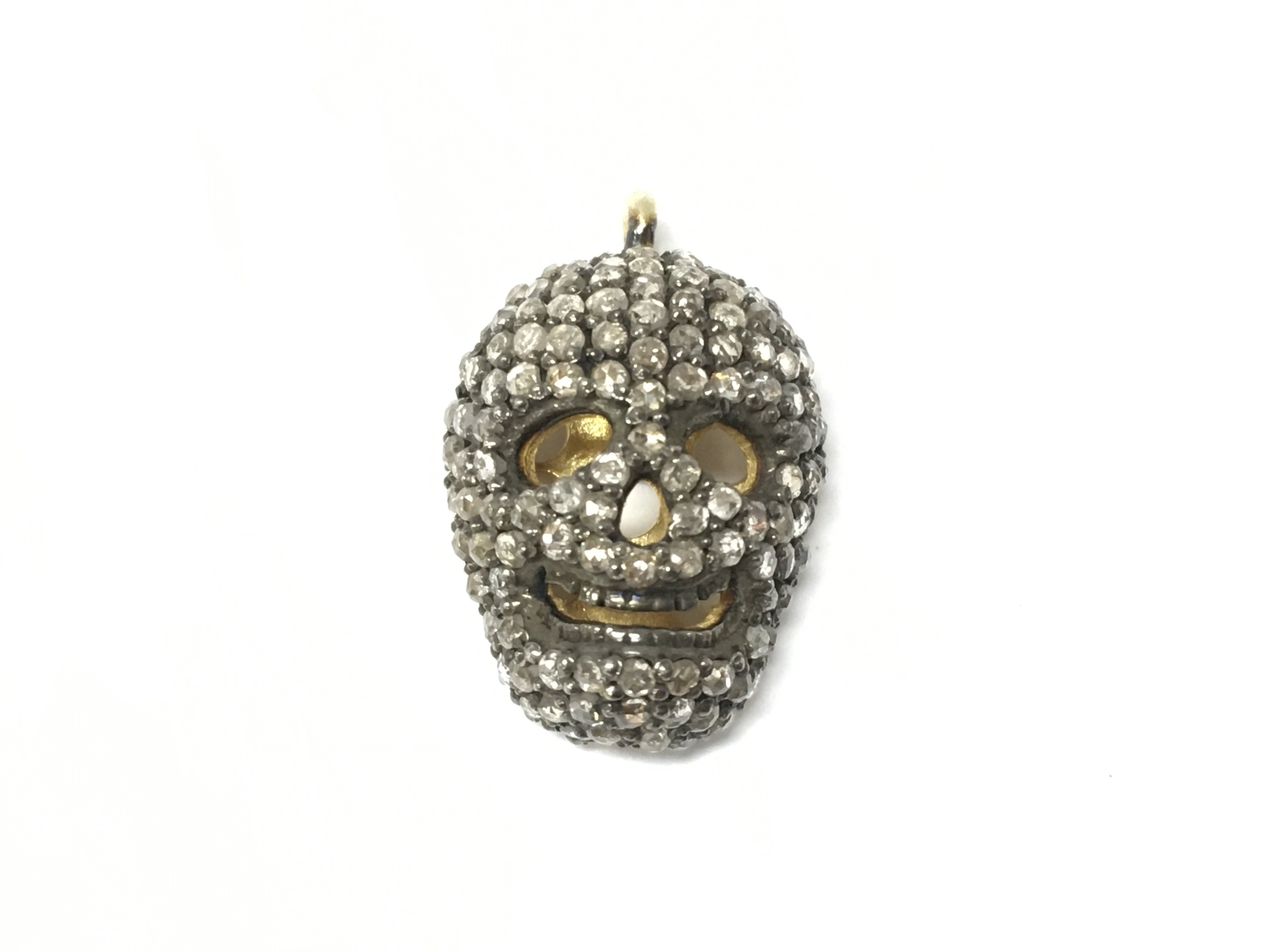 A silver and gold plated diamond set skull pendant. Diamonds 0.65ct Approx and 0.5cm length.
