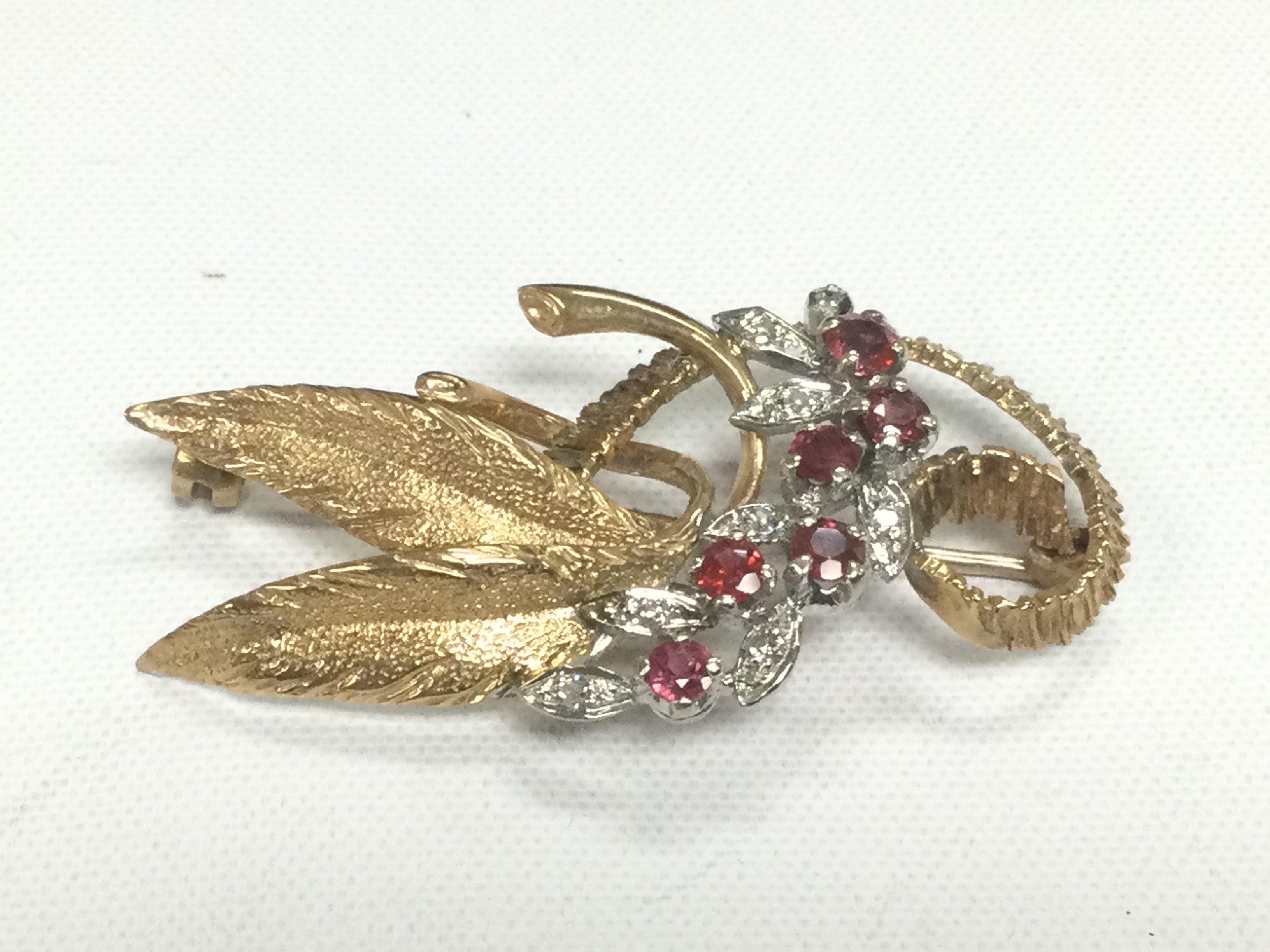 A 9ct gold ruby and diamond floral brooch, approx 7g. Shipping category A.