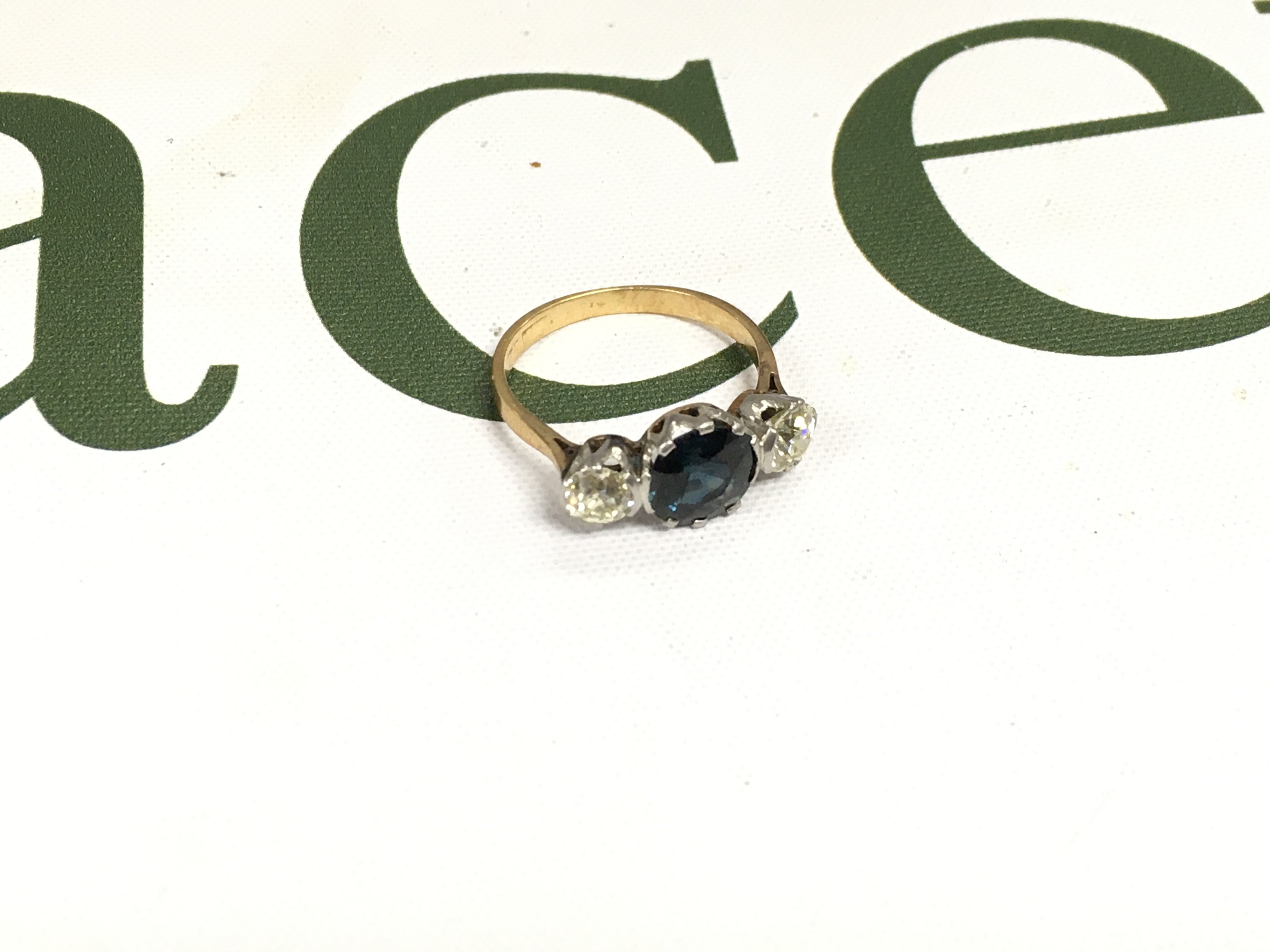 A three stone ring set with two old cut diamonds on the side with an alexandrite set in the centre. Approx weight 3.48 grams, approx size O.