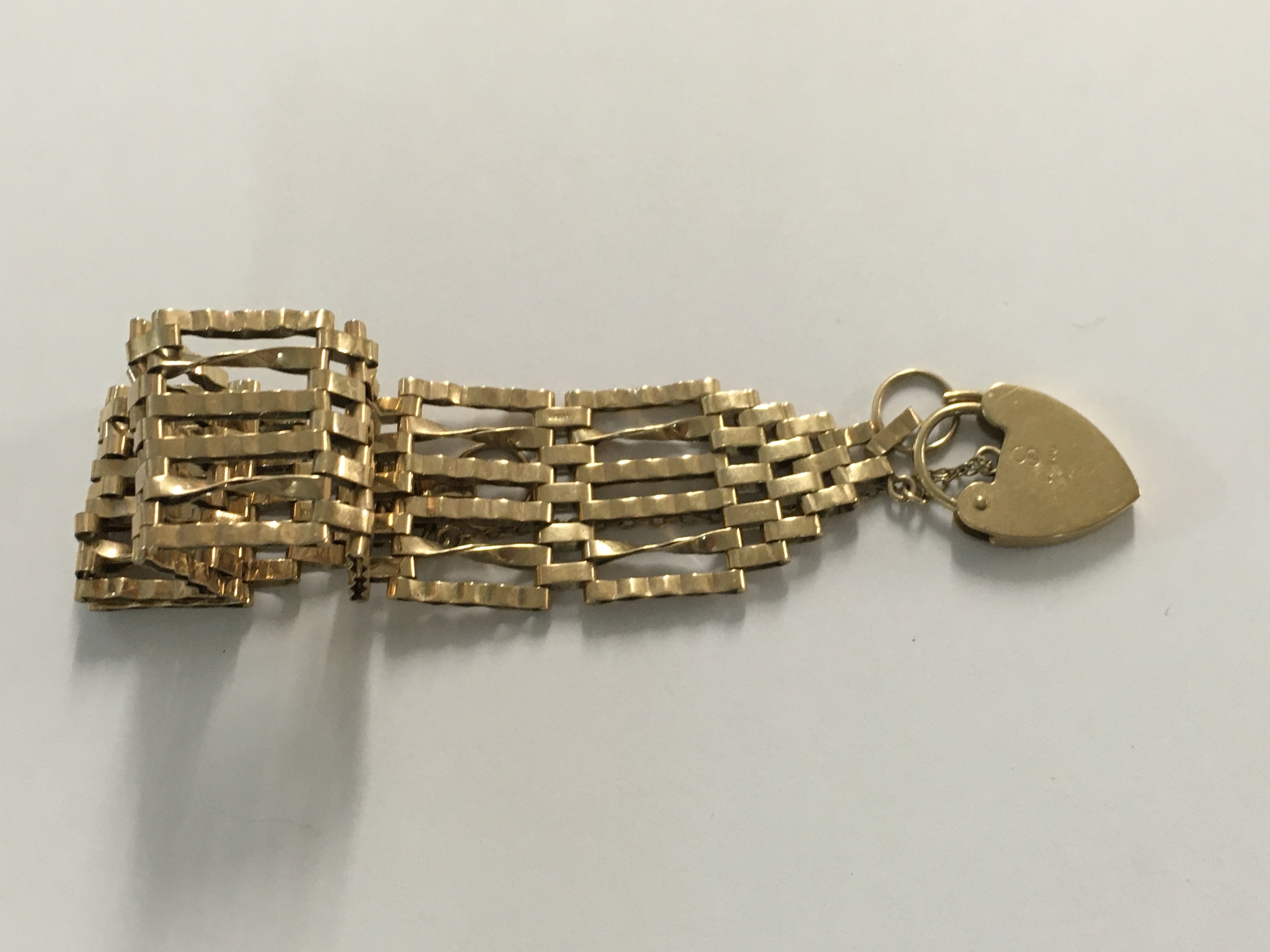 A 9 ct gold gate bracelet with heart clasp 11..90 grams.