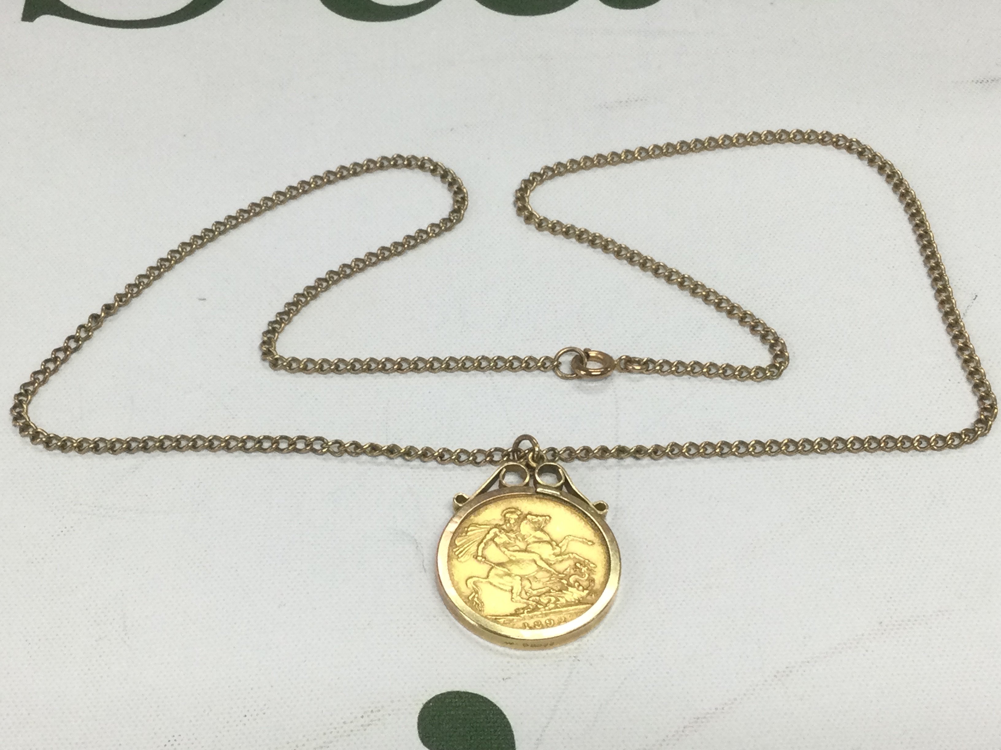 An 1892 gold sovereign set in a gold mount and suspended on a gold chain, Shipping category A.