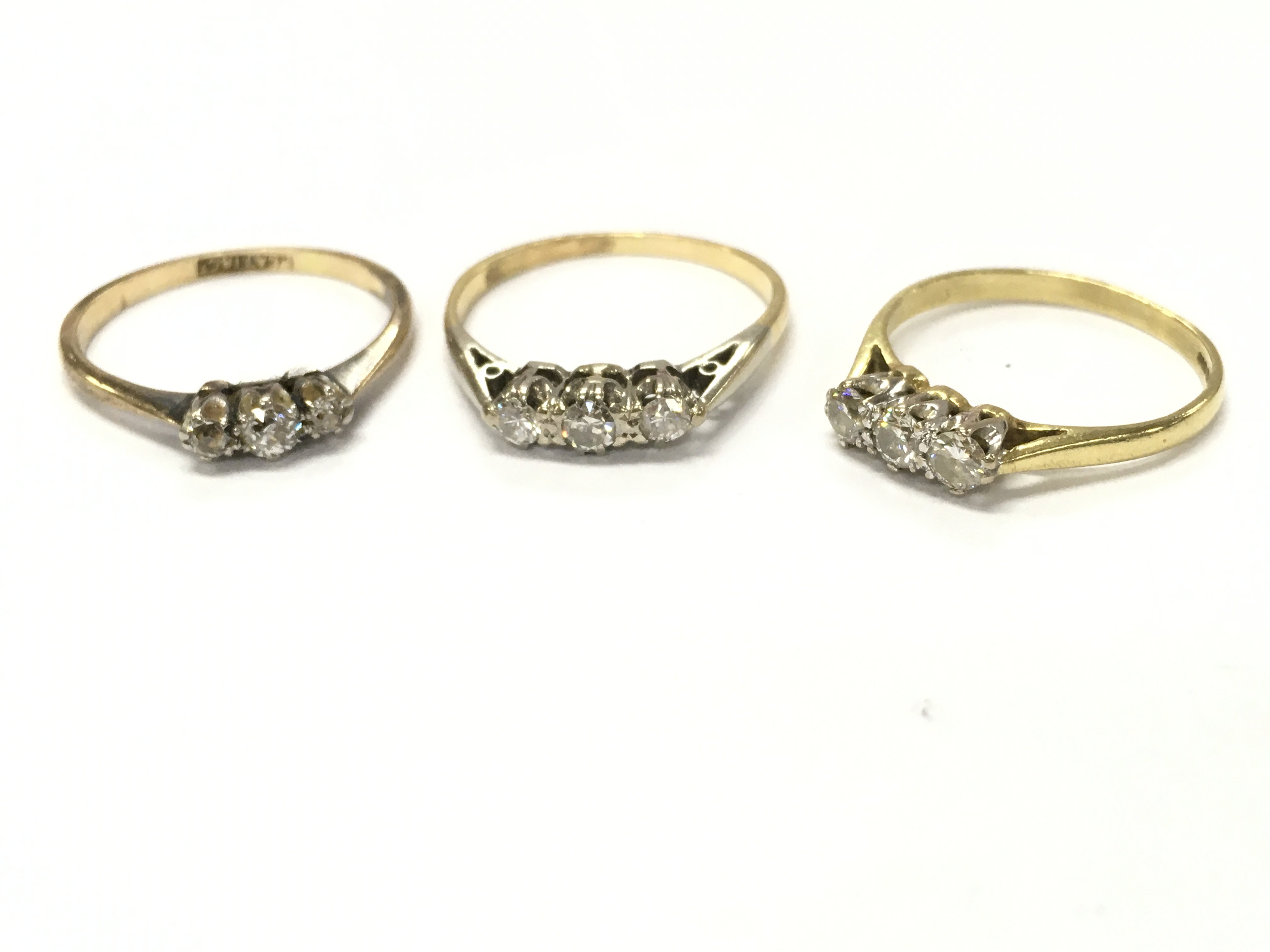 An 18ct three stone diamond ring, sizes K/L, N, L. 5.6g total weight Postage category A