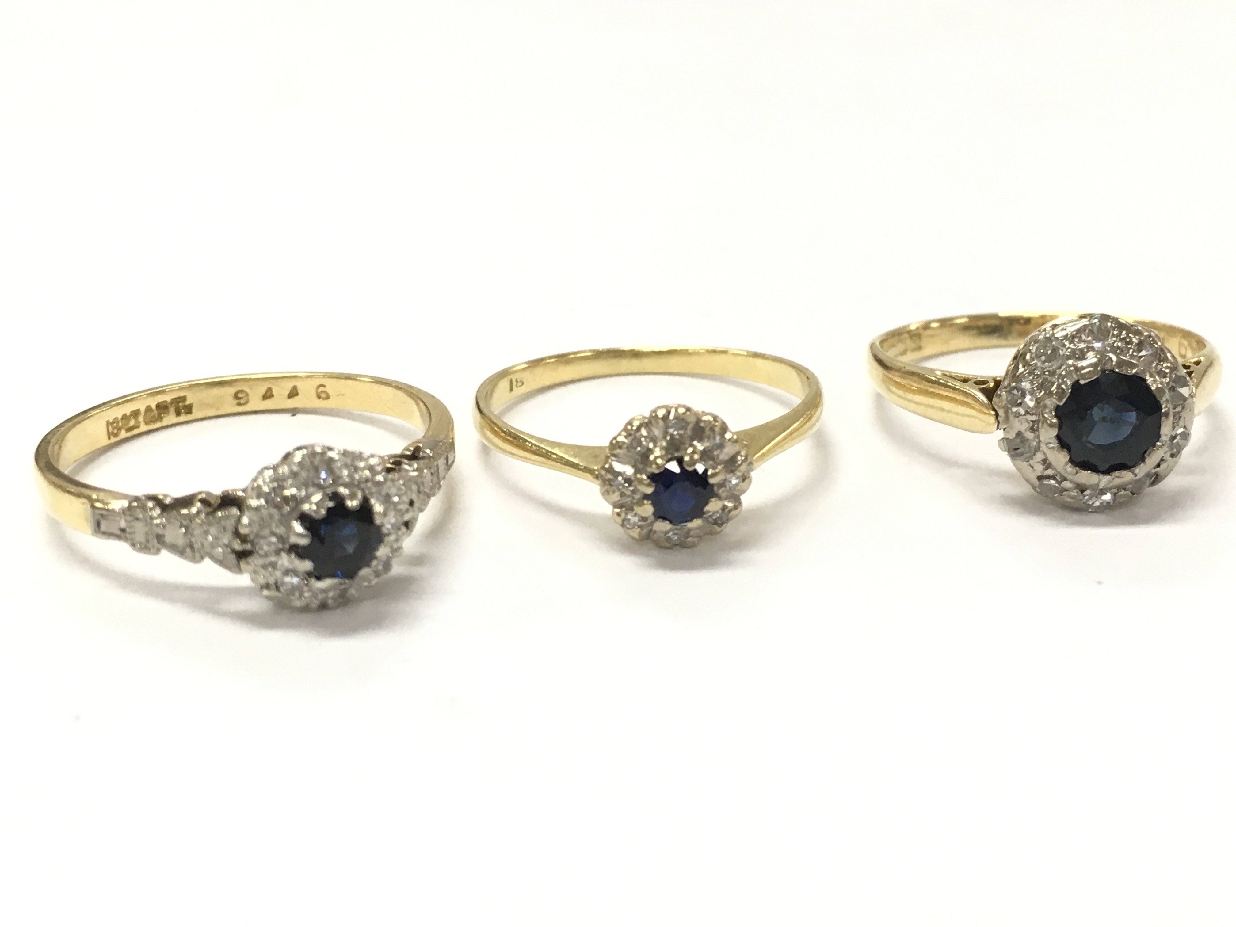 Three 18ct gold sapphire and diamond cluster rings, size J, K, N/O. 7.1g total weight