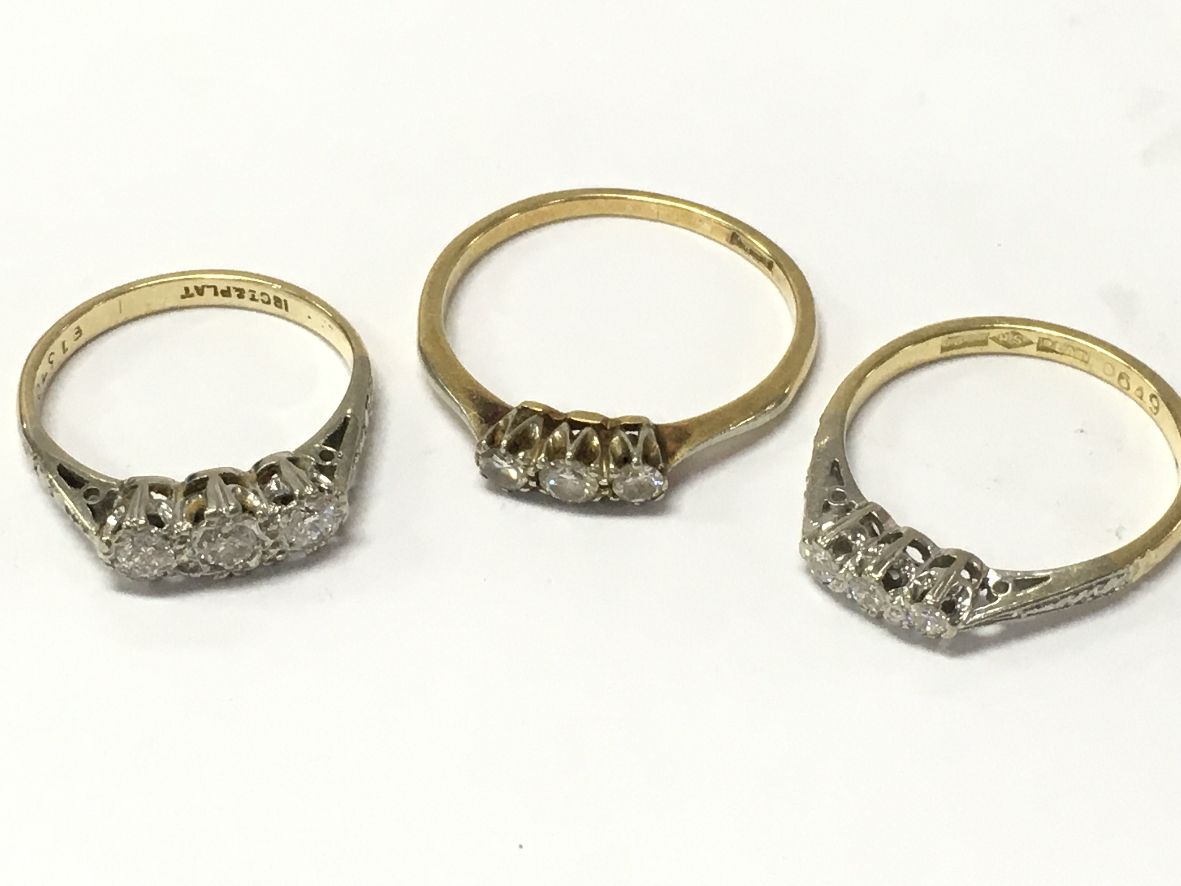 18ct gold and platinum three stone diamond rings . 7g total weight Postage category A