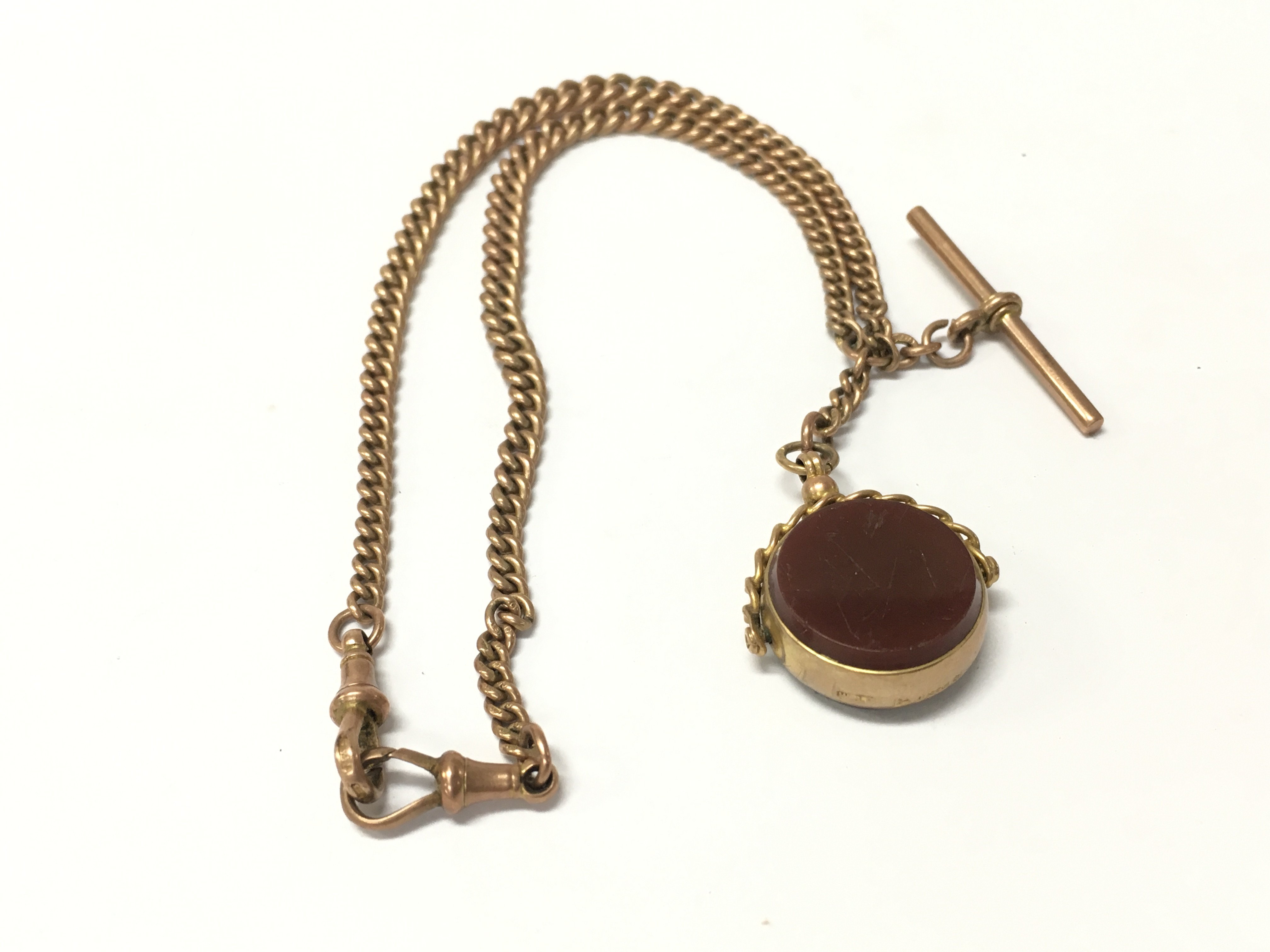 A 9ct gold graduating Albert chain with a spinning fob and T-bar attached.