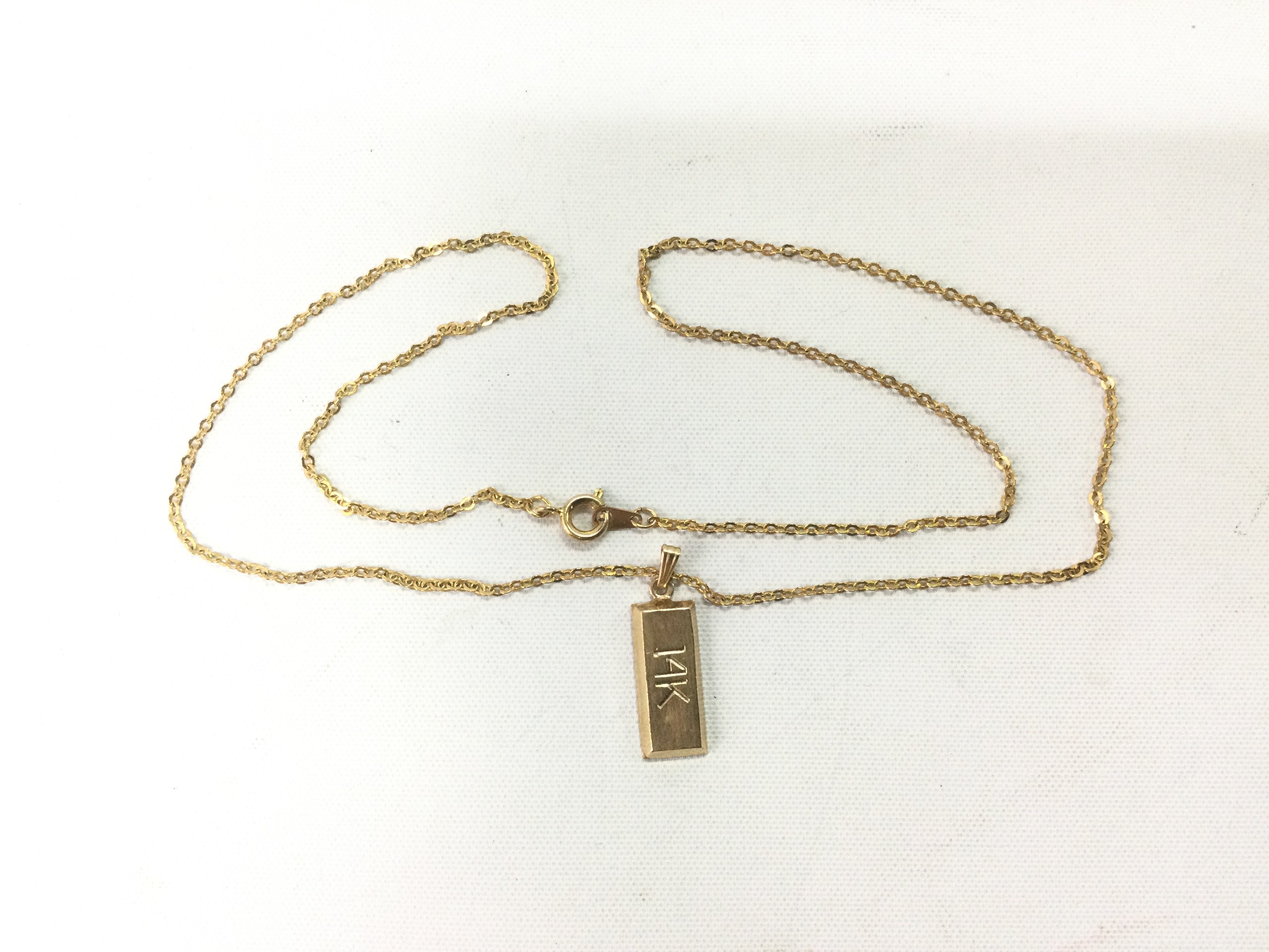 A 14k gold pendant on a chain (not gold). Pendant approx 1.2g. Shipping category A.