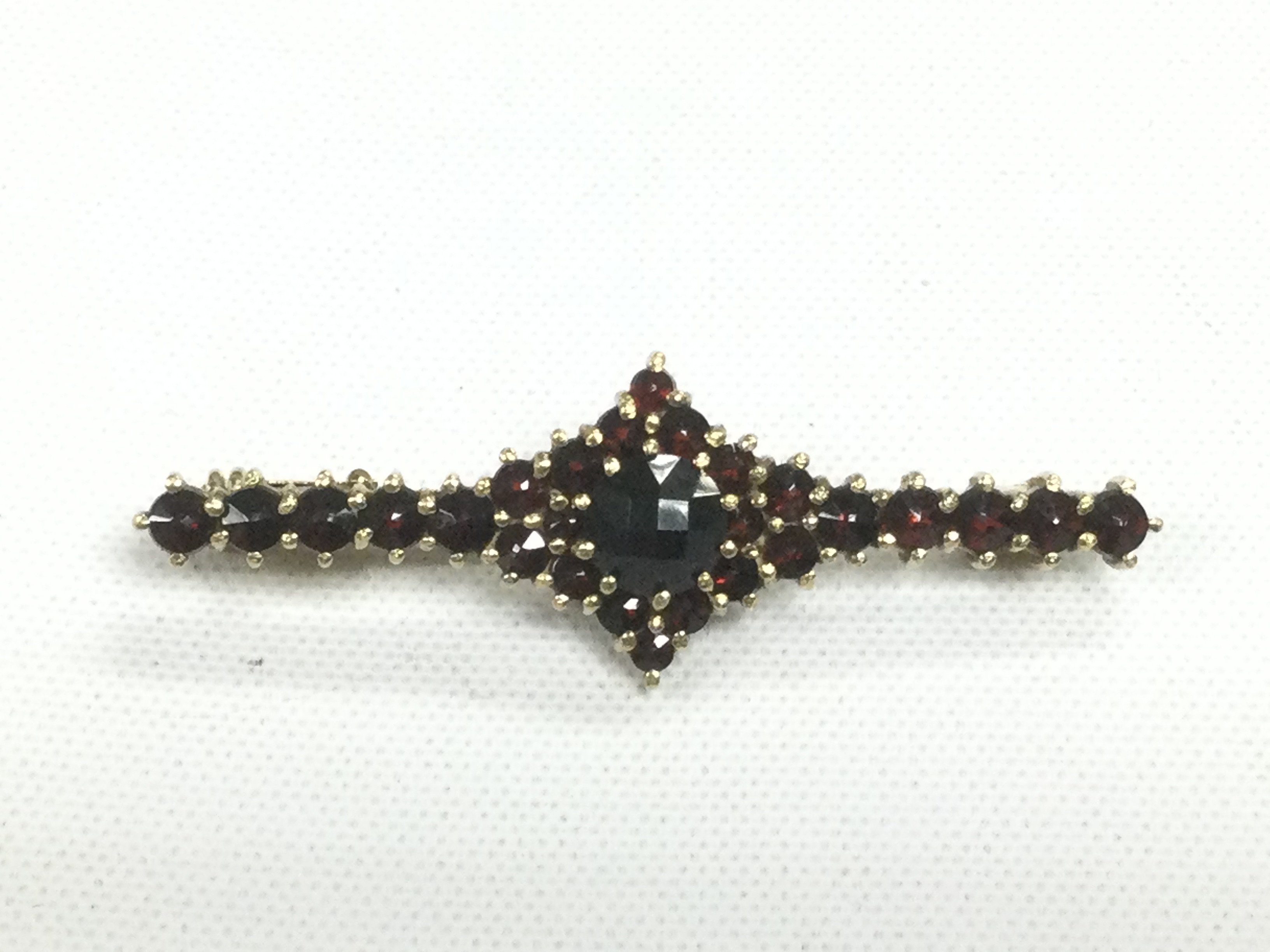 A 14k gold brooch set with rubies, approx 4.2g. Shipping category A.