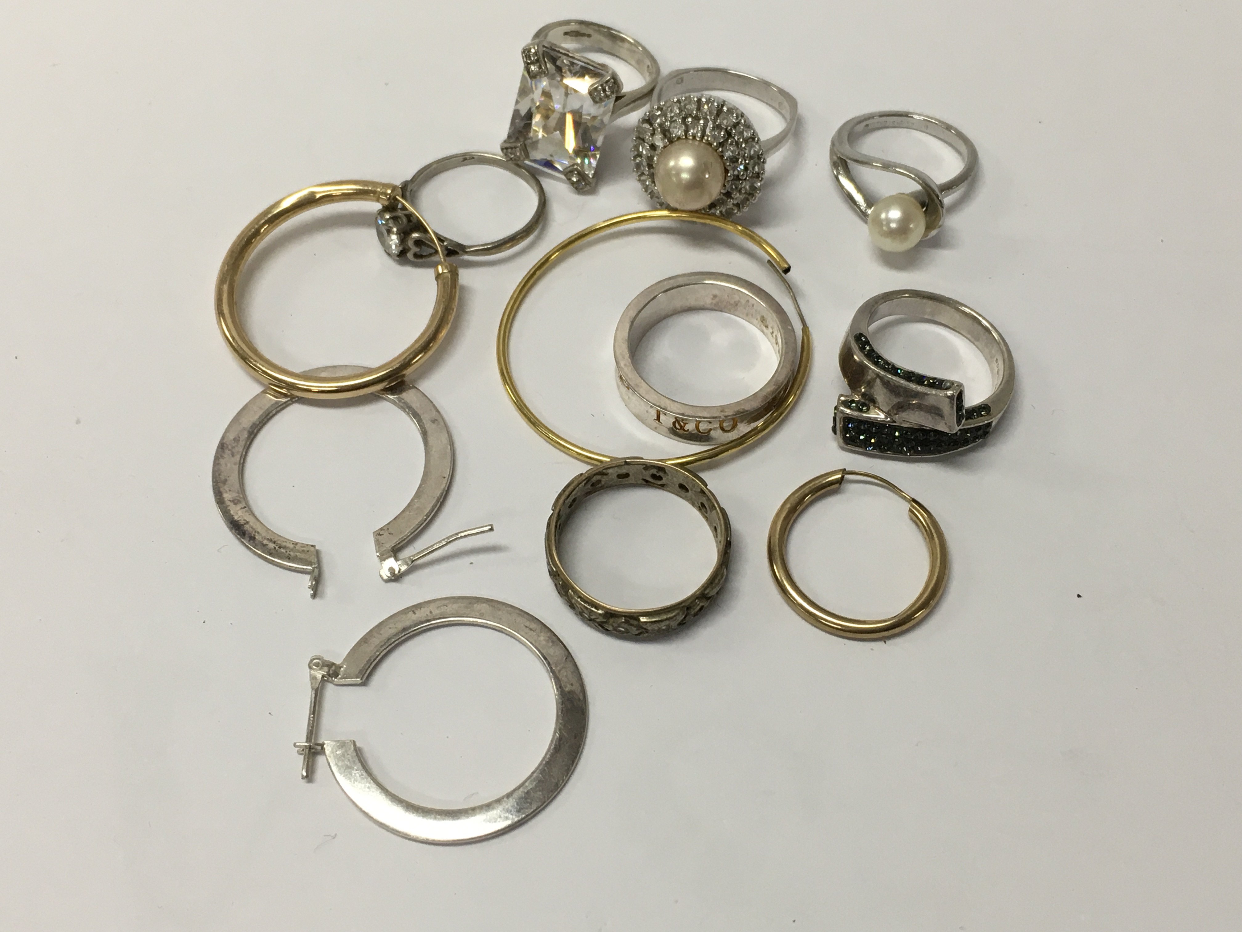A collection of rings including silver together with loose earrings.