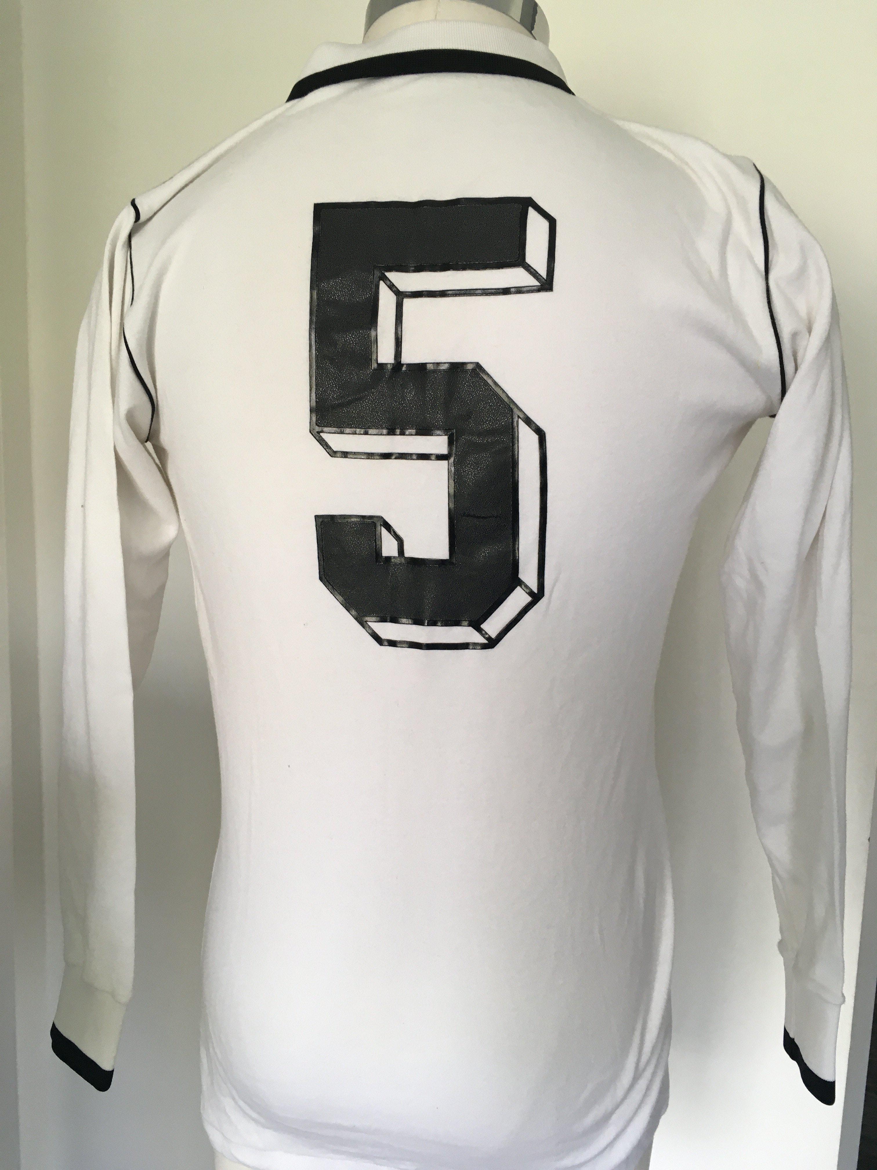 1979 Germany Match Worn Football Shirt: White long sleeve Erima shirt with number 5 to rear. Worn in the match v Republic of Ireland on 22 5 1979. Swapped with Eire player Mick Martin, who is prepared to offer a COA. Mick can not remember name of opposing player.