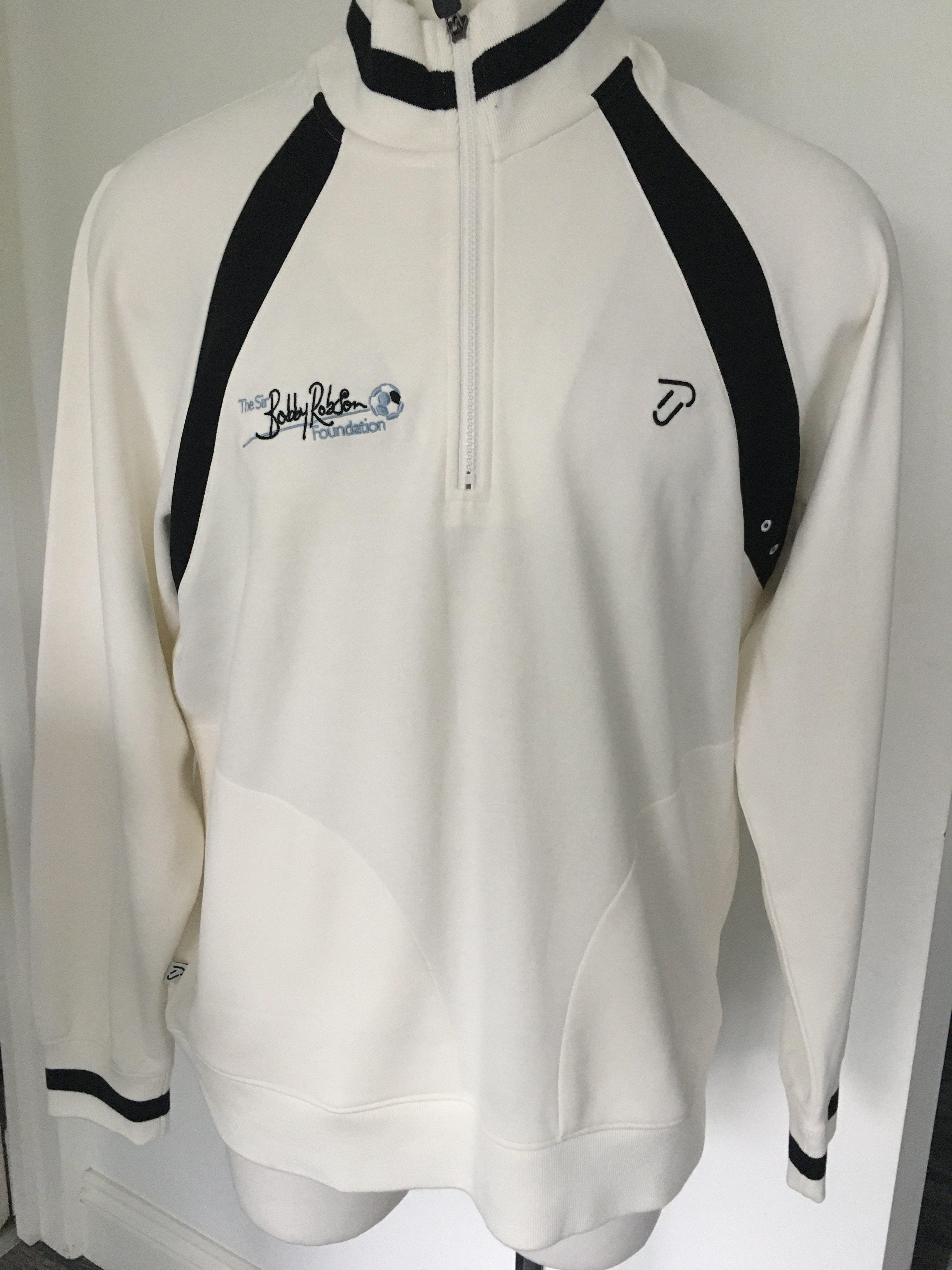 Sir Bobby Robson Foundation Track Suit Top: Designed by golfer Ian Poulter and used for charity golf days for the foundation. Excellent condition rare item given to Newcastle Utd ex player Mick Martin. Black and white to emphasise the Newcastle element. Size XXL. Thick quality garment is like new.
