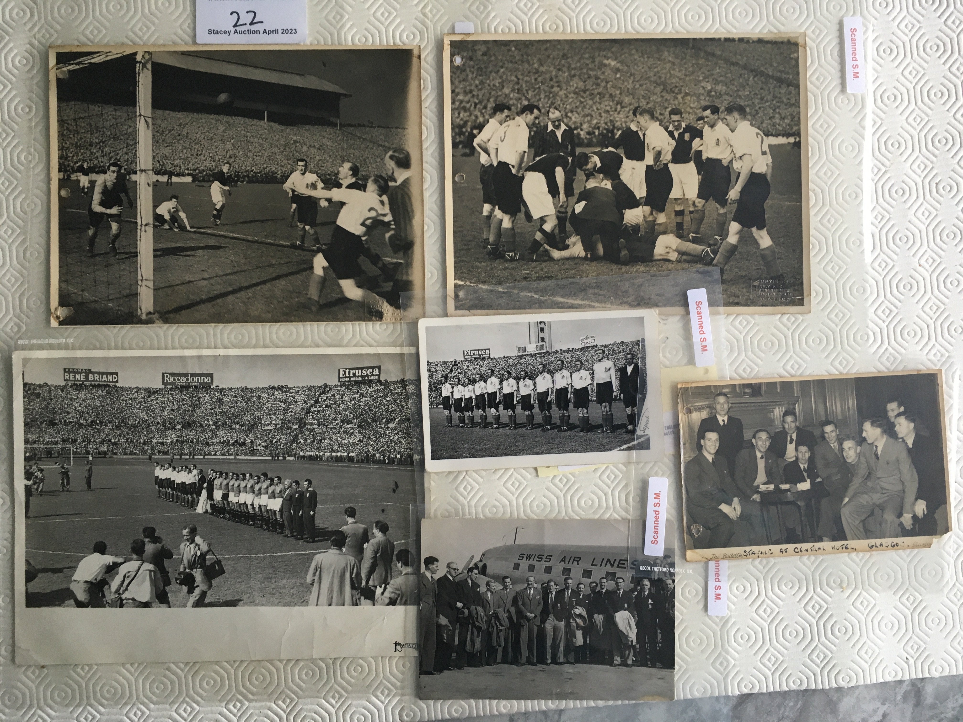 England 1940s Football Press Photos: Two match action at Hampden Park in 1946 and a smaller one of the England team at the hotel without press stamp. Postcard size of the England team and a larger one of both teams lining up in Italy 1948. Postcard size of the squad outside aeroplane in Switzerland 1947. Press stamps and information to rear unless stated with 3 having discreet punch holes to border. (6)
