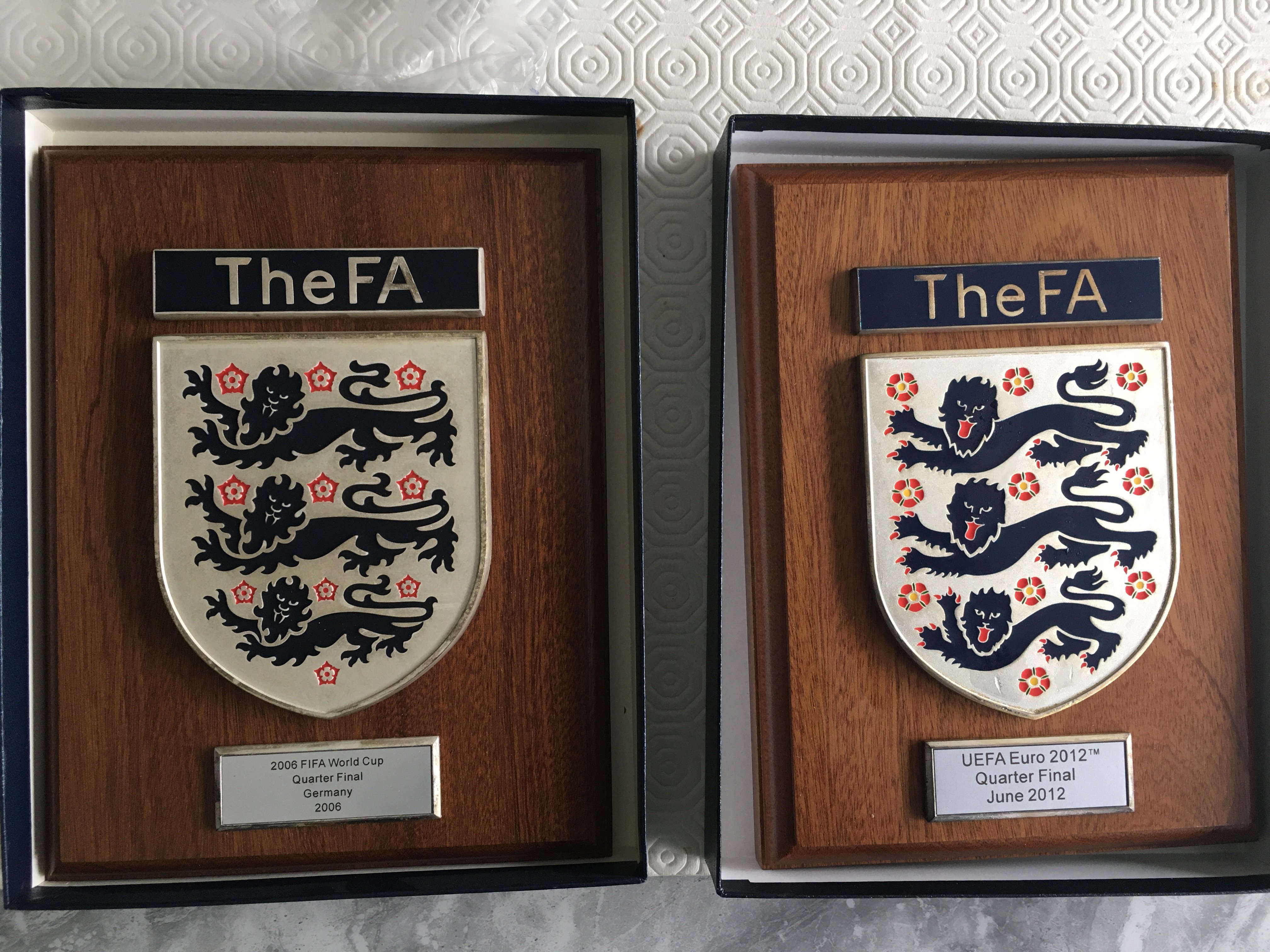 England World Cup + Euros FA Football Plaques: Top quality heavy wooden plaques with thick metal plaque stating The FA with 3 Lions crest. A further plaque states 2006 FIFA World Cup Quarter Final Germany 2006 the other UEFA 2012 Quarter Final June 2012. Boxed items measure 9 x 7 inches and are too good to be a corporate gift. Possibly presented by the FA at these matches. (2)