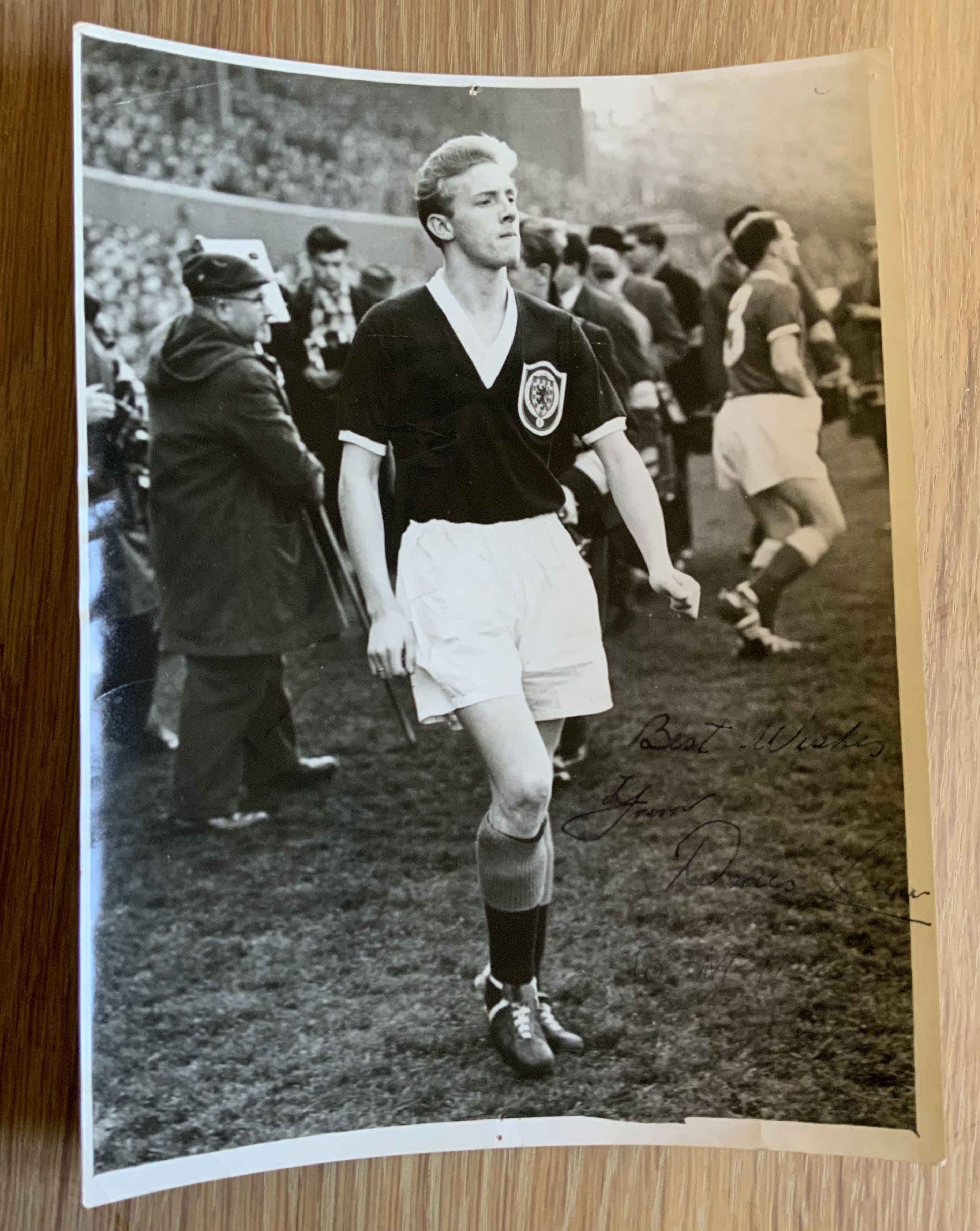 George Best + Denis Law Signed Football Picture: Large colour magazine picture featuring both Manchester United players in their respective Scotland and Northern Ireland kits. Both clearly hand signed without dedication. Measures just over 8 inches square.