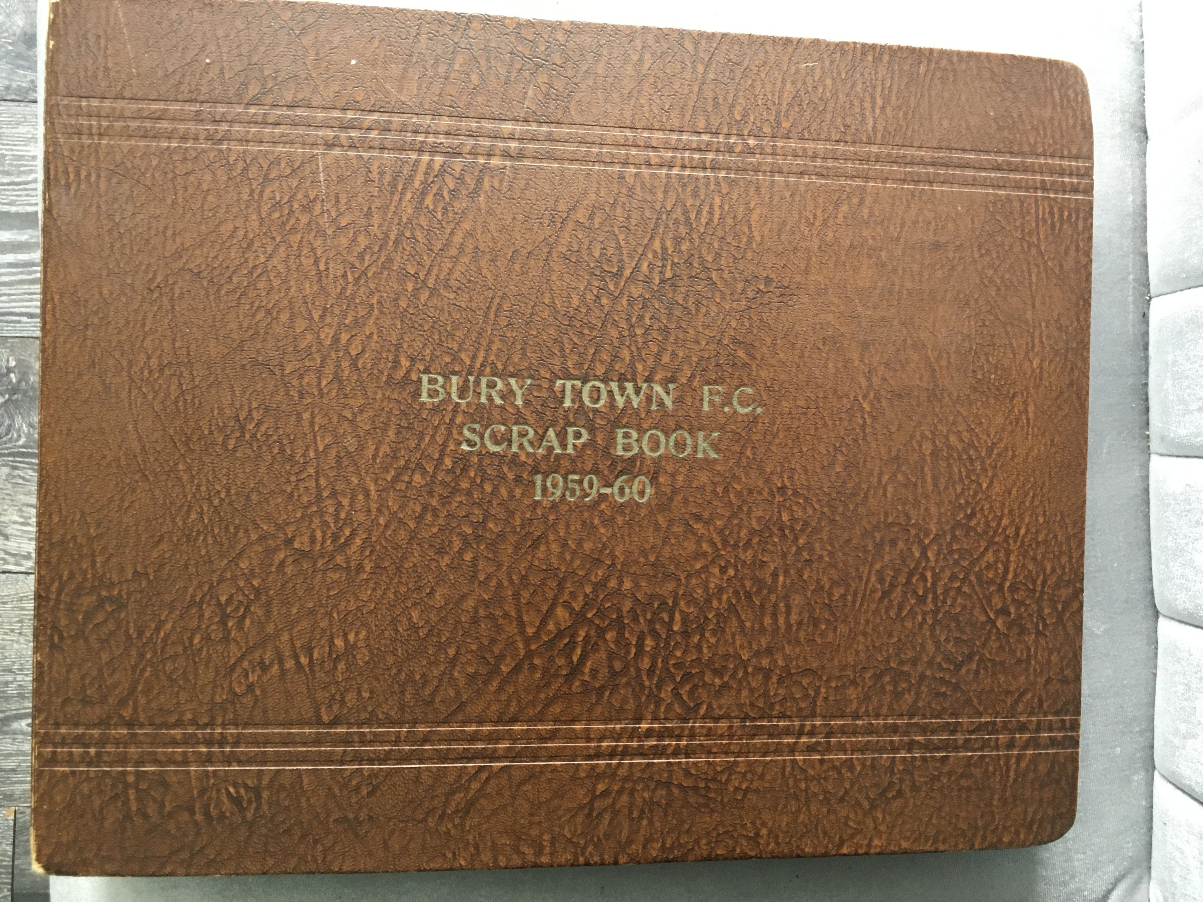 Bury Town Football Scrapbook 1959 - 1960: Title is the exact words embossed on what was possibly the clubs own scrapbook. Inside cover has 14 autographs of the players and the rest has concise 1st team and reserves match reports plus programmes.