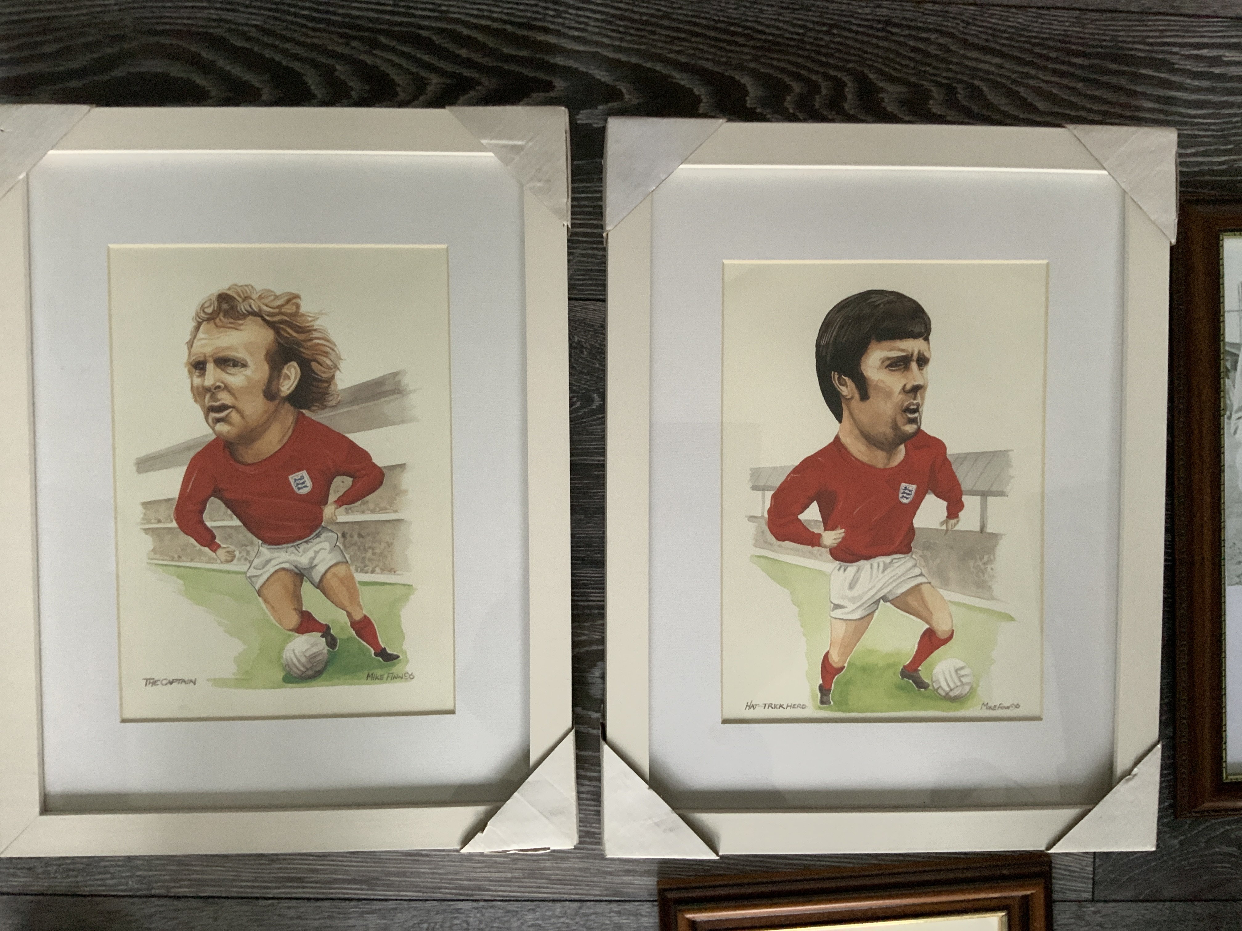 Hurst+ Moore West Ham Framed Football Prints: Two large, nicely framed caricatures of Hurst + Moore in the red World Cup winning kit. C/W a duplicate Moore in a lesser frame and one more. Instructions to sell. (4)
