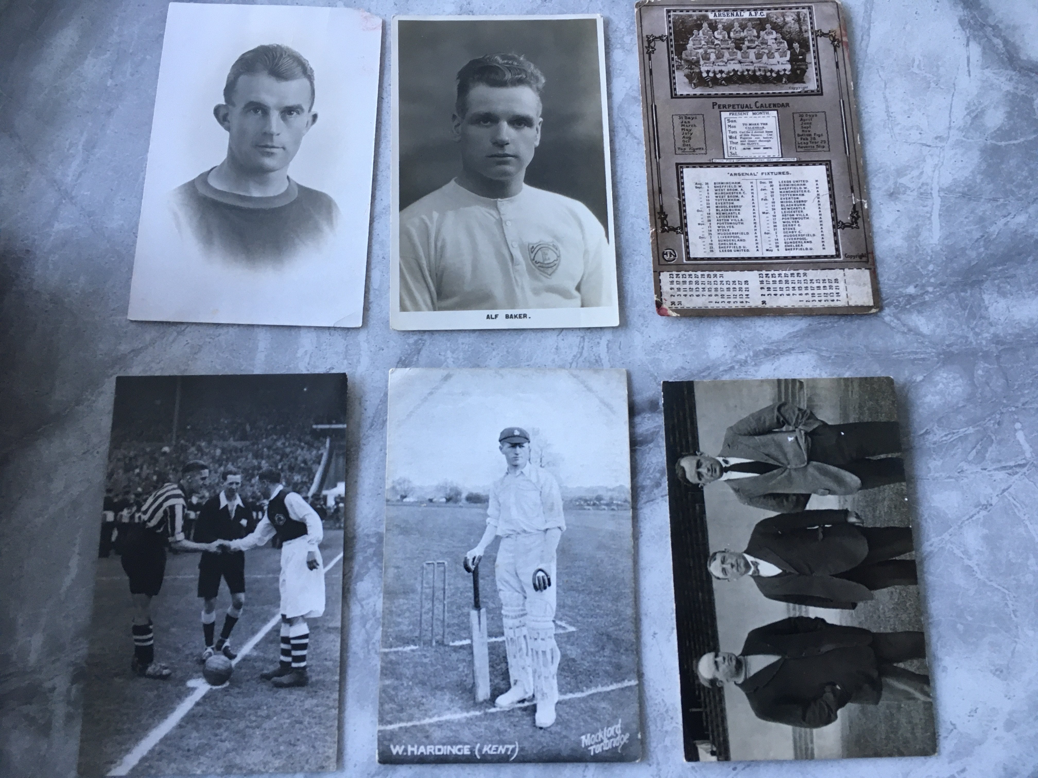 Arsenal Pre War Football Postcards: Original postcards featuring captain shaking hands before 1936 FA Cup final excellent, Leonard Thompson tiny piece out of corner, Alf Baker excellent, Training team of Hardy McQueen and Ratcliff very good, 33/34 Calendar/fixture postcard tear and Hardinge who played both cricket and football for England in cricket attire good. (6)