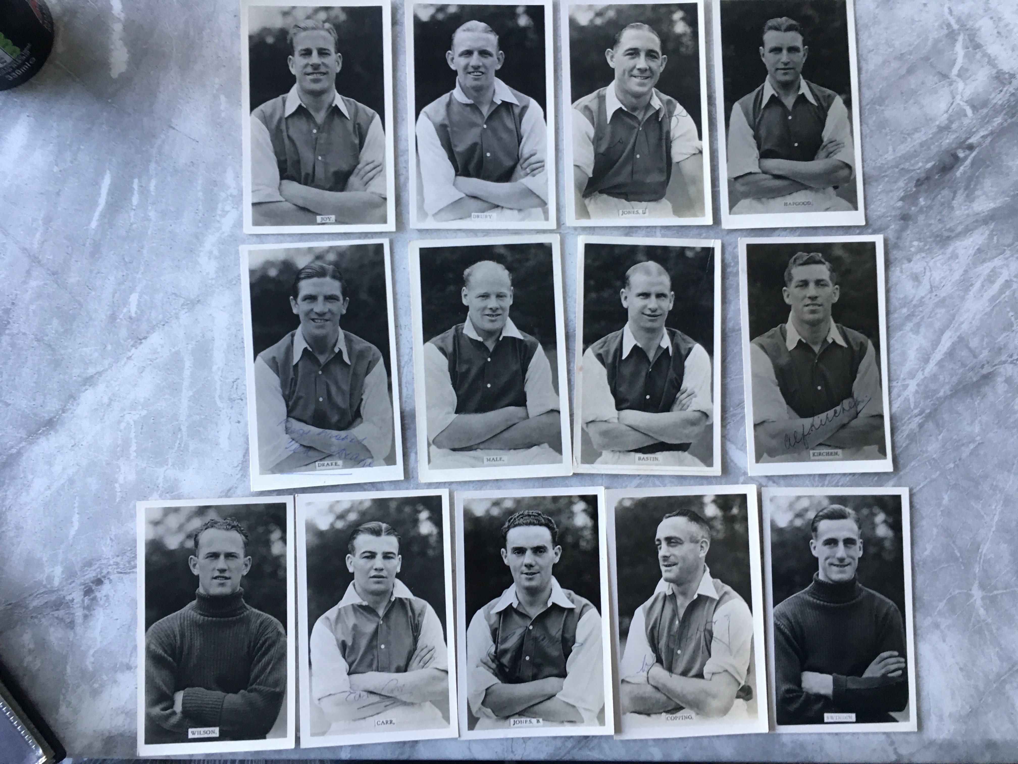 Arsenal 38/39 Signed Football Player Postcards: Original postcards from around 1938 including hand signed by Carr B Jones L Jones Drake Kirchen and Copping. Other players from the set of pictures taken from waste upwards are Wilson Swindin Bastin Male Hapgood Drury and Joy. All from the same set and not to be mixed up with a similar set of full length photos. 8 have press stamps to rear and 2 have evidence of being previous Y stuck down to rear. Rare chance. (13)