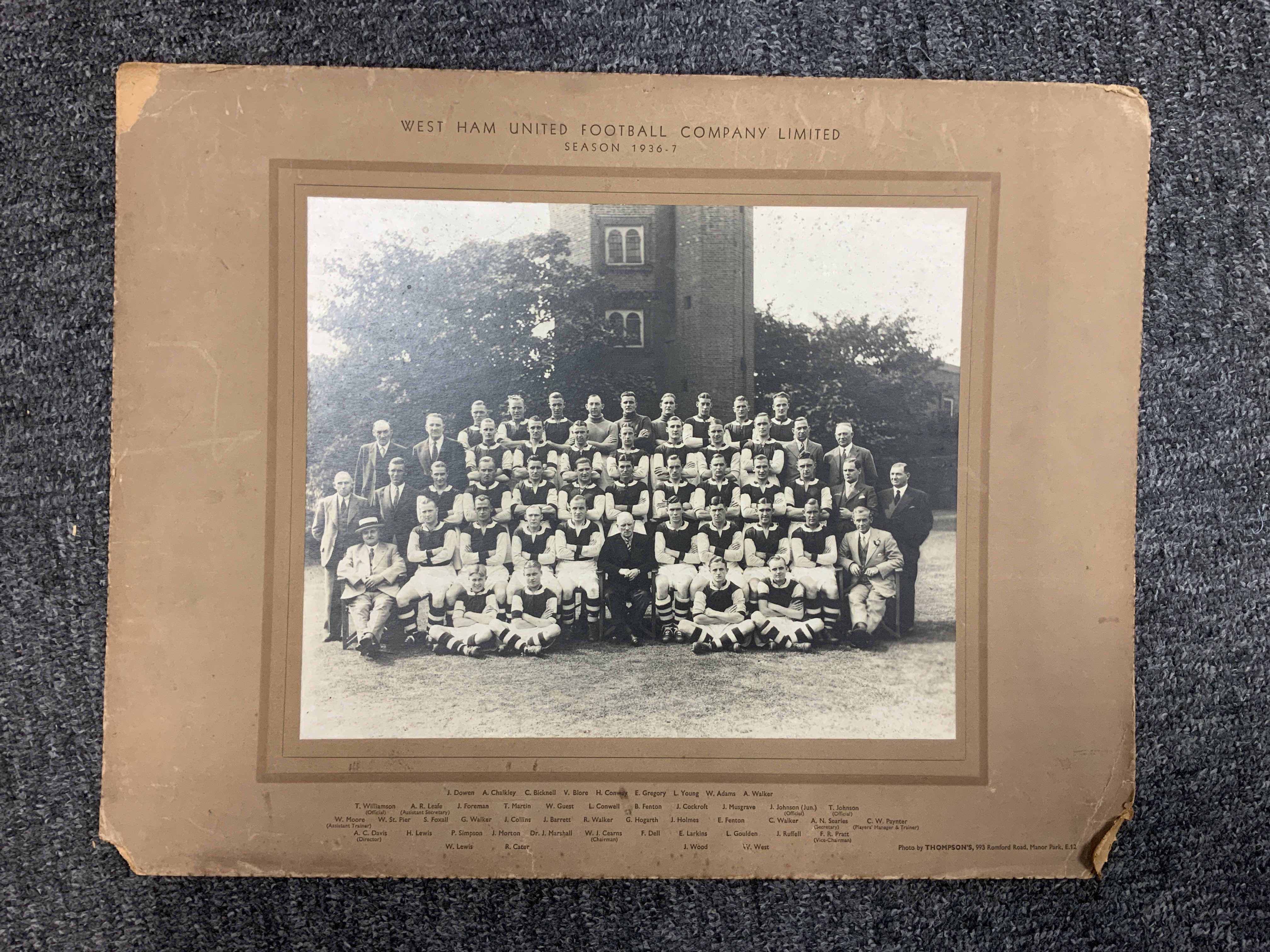 36/37 West Ham Official Large Football Squad Picture: All the players and staff pictured with names printed underneath on brown board. This original item is often found in the directors boardroom but sometimes given to players. Board, which has damaged corners not affecting photo, measures 18 x 14 inches.