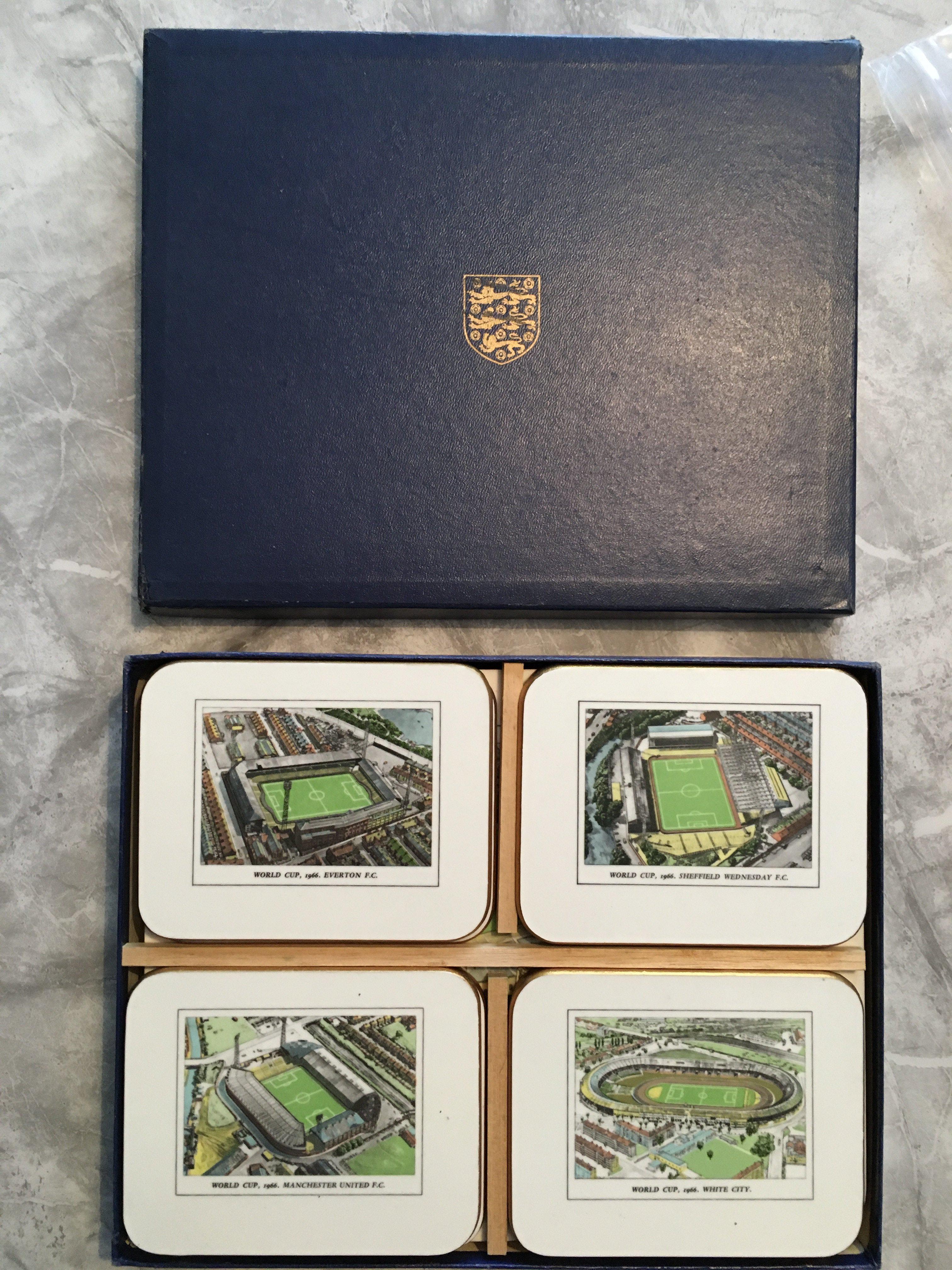 1966 World Cup Set Of Placemats + Coasters: 8 unused coasters and 8 unused place mats each depicting a football ground used in the World Cup. In original box with 3 Lions to front and spacers for the coasters. Unusual to see gold edging like new and baize to rear in perfect condition.