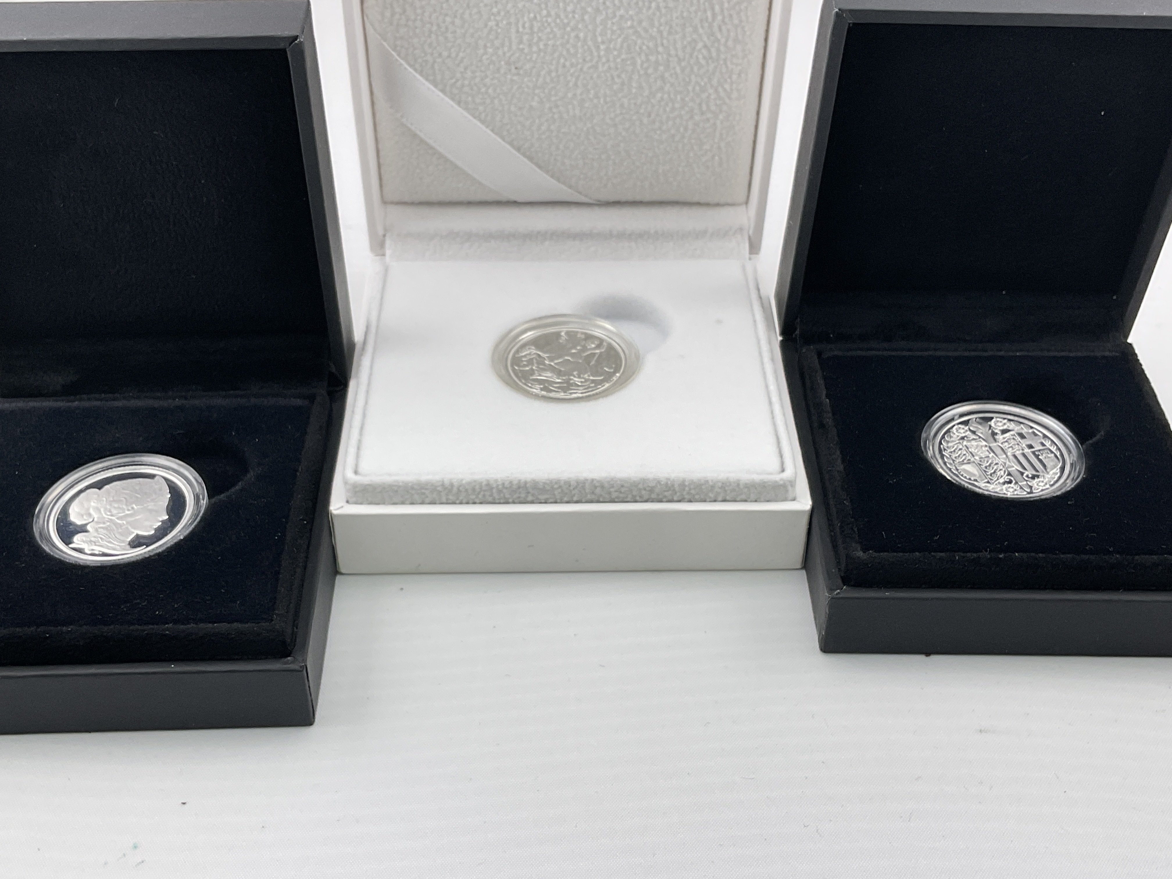A proof silver sovereign and two further silver coins. Postage category A.