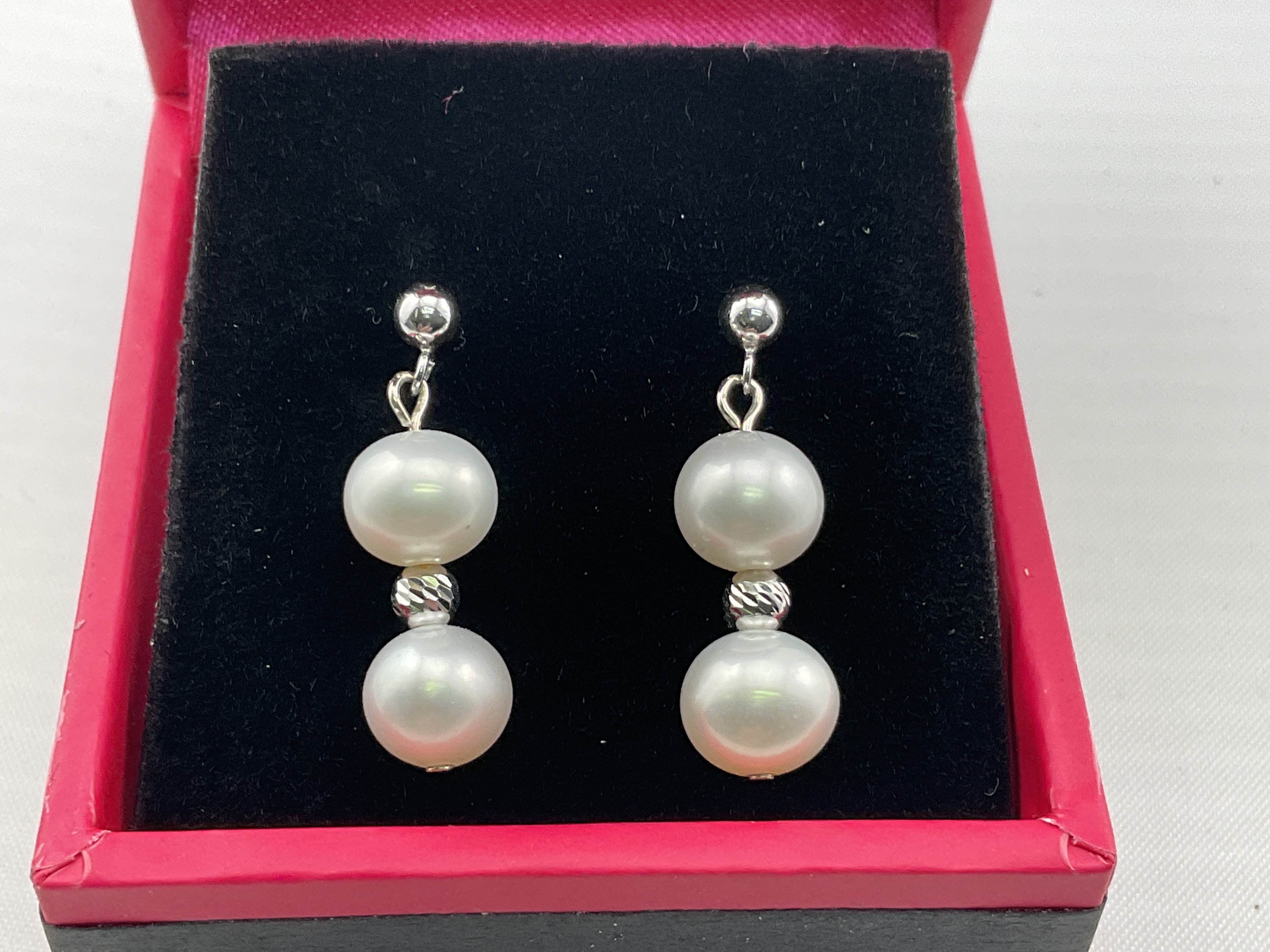 A pair of 9ct white gold and pearl drop earrings. Postage category A.
