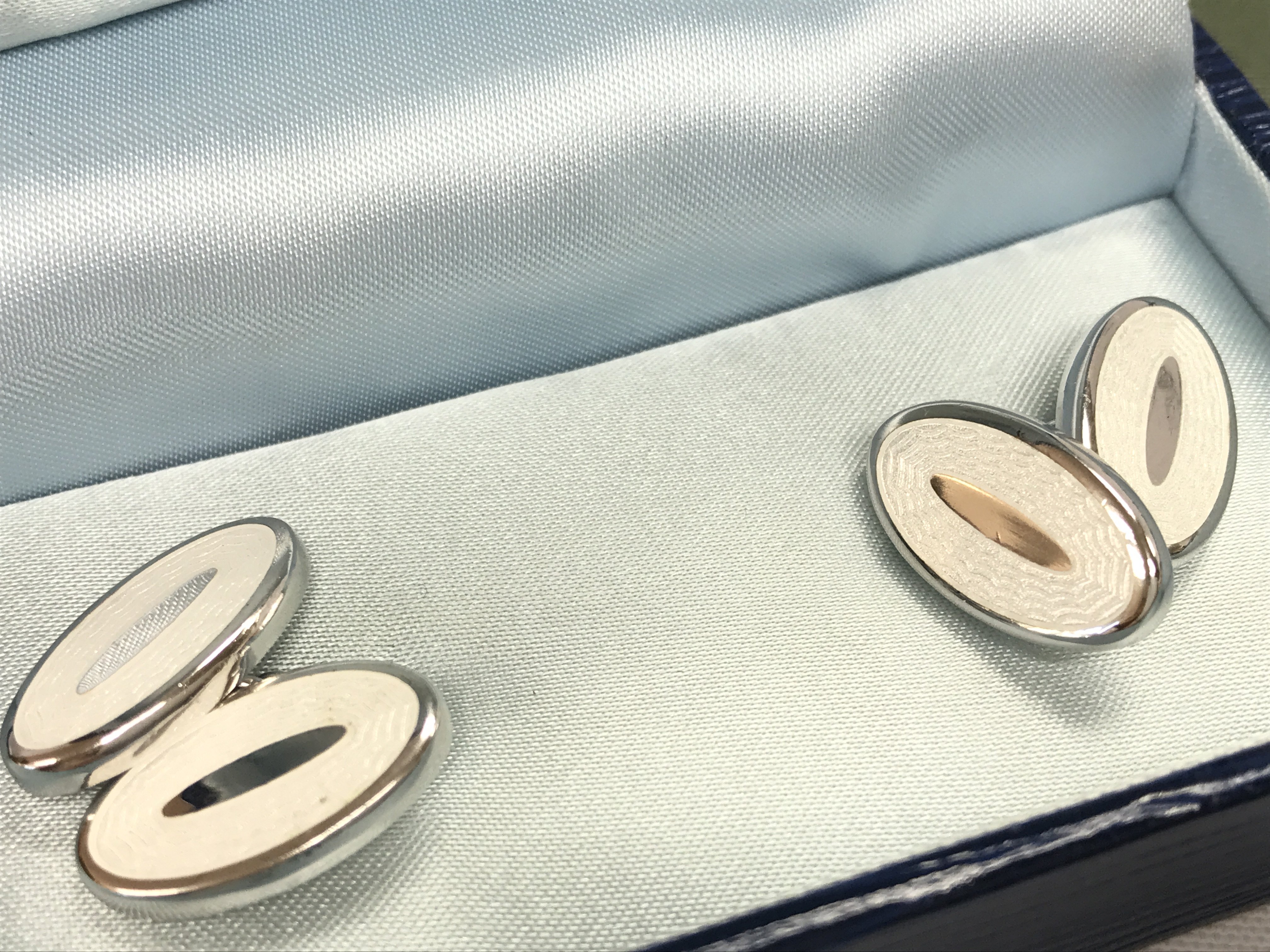 A white metal Links of London bracelet and a boxed pair of enamel and silver cufflinks. Postage cat A