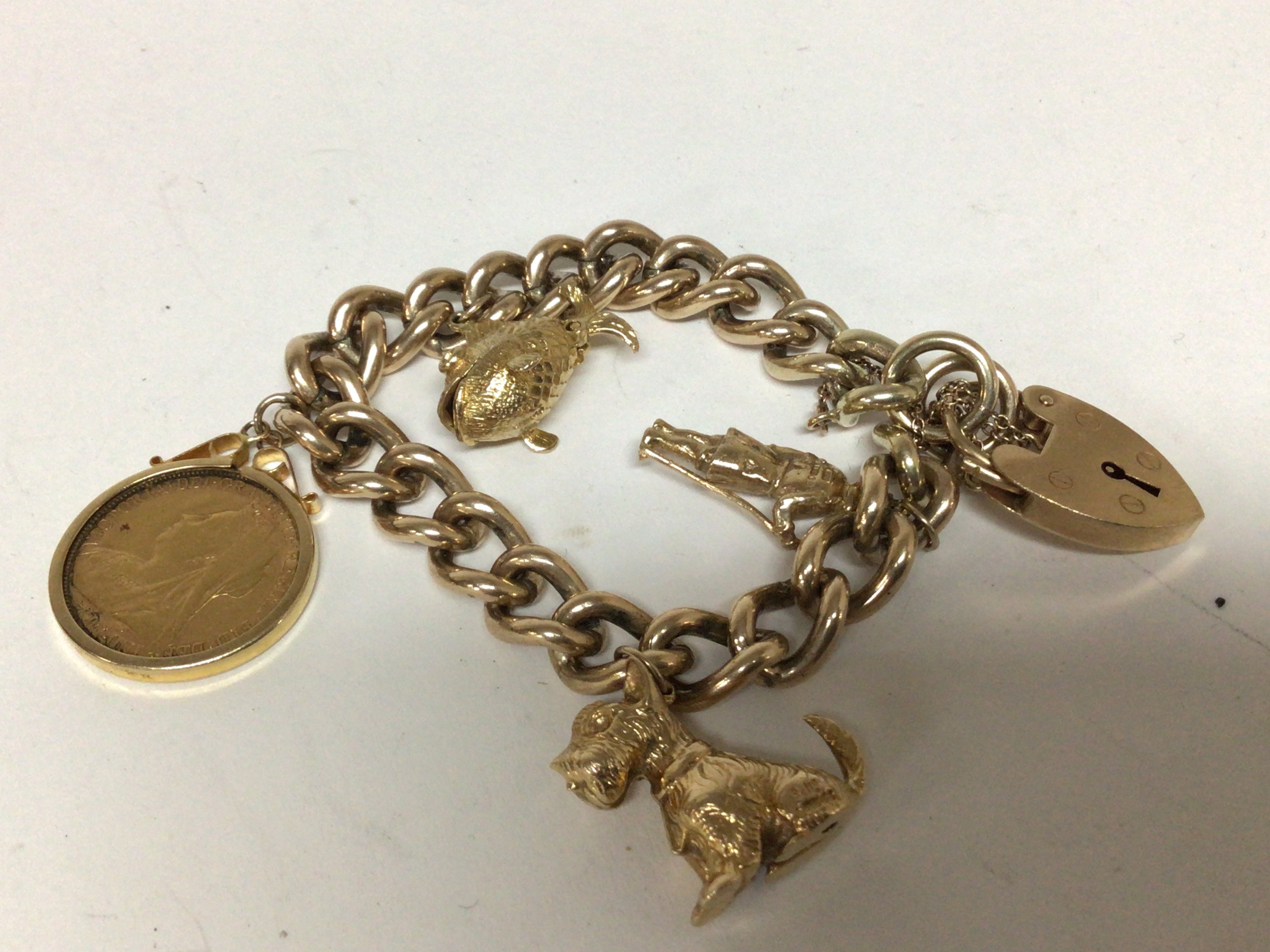 A 9carat gold charm bracelet with attached 1899 Victorian Sovereign and gold charms total weight 63g