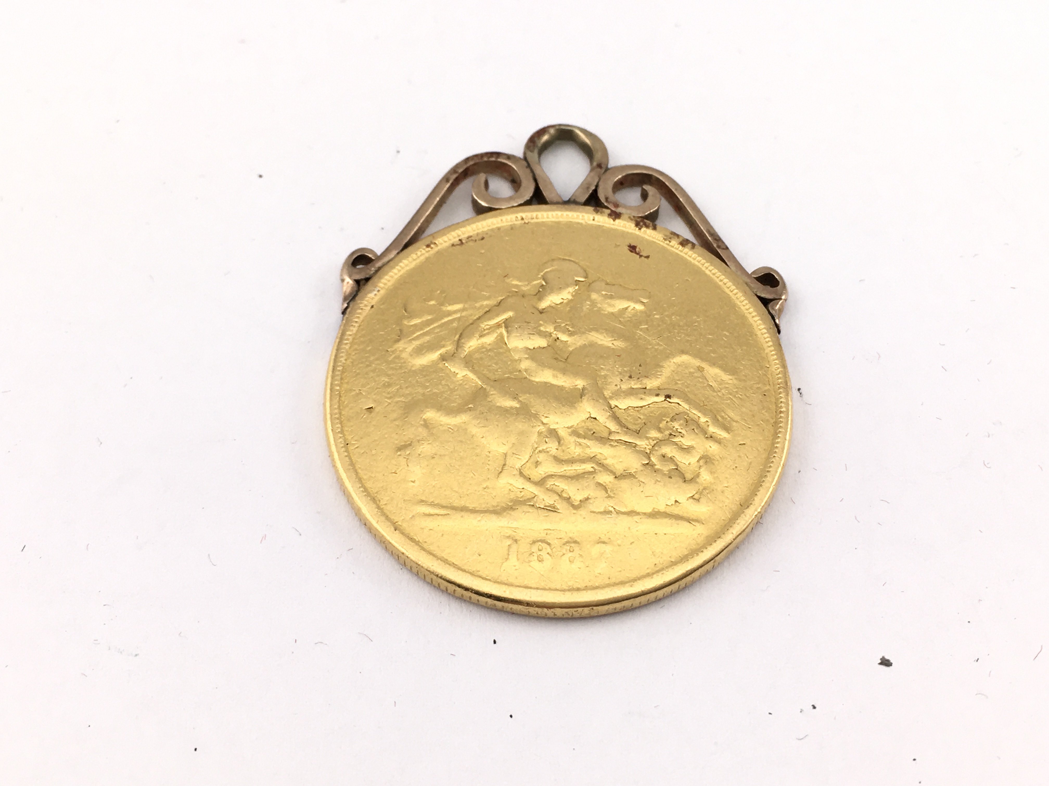 A 1887 &pound;5 gold coin with mount. 41.17g Postage A