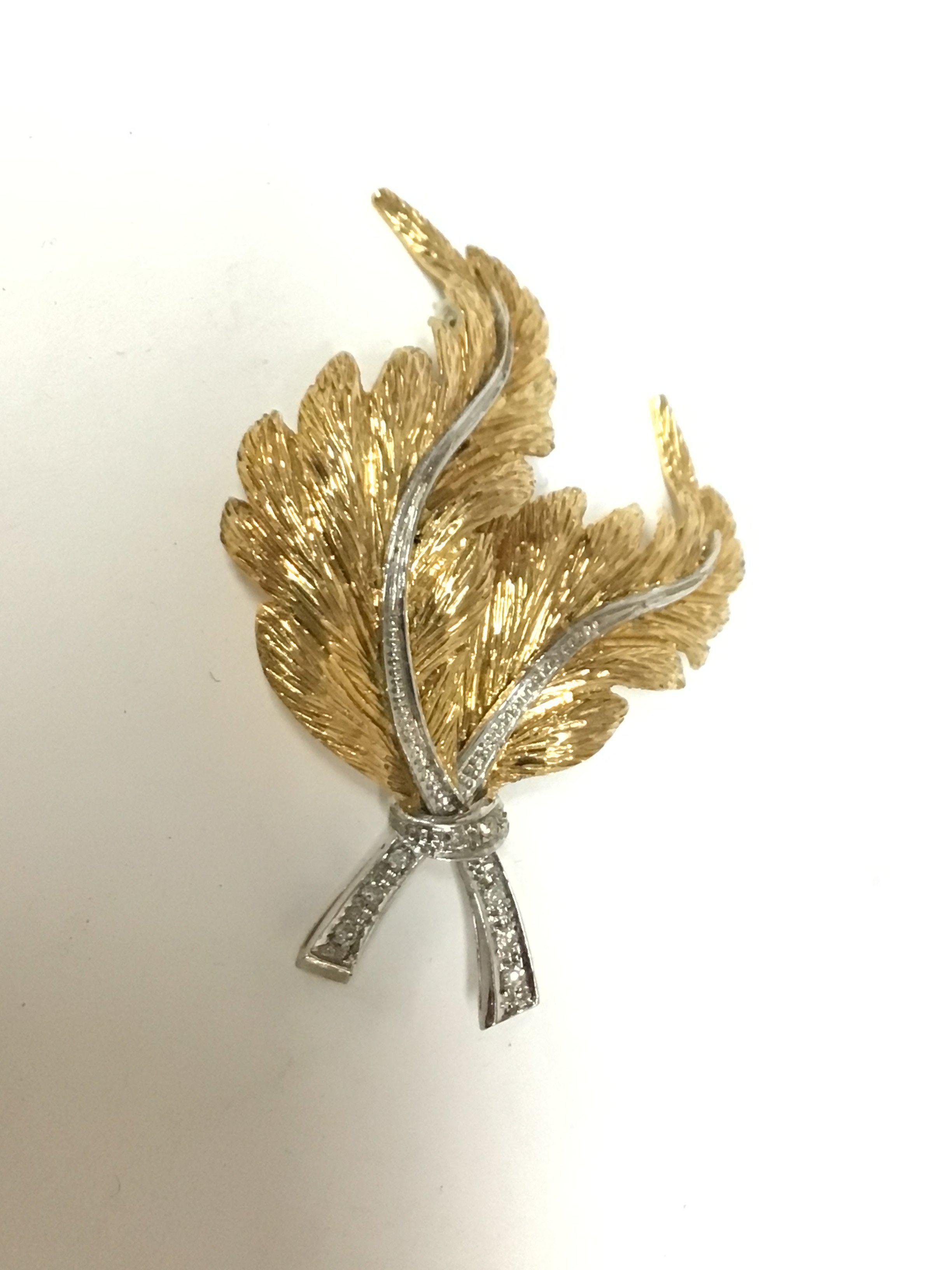 An elaborate 18carat gold brooch with white and yellow gold with small diamonds. Weight 12.8g