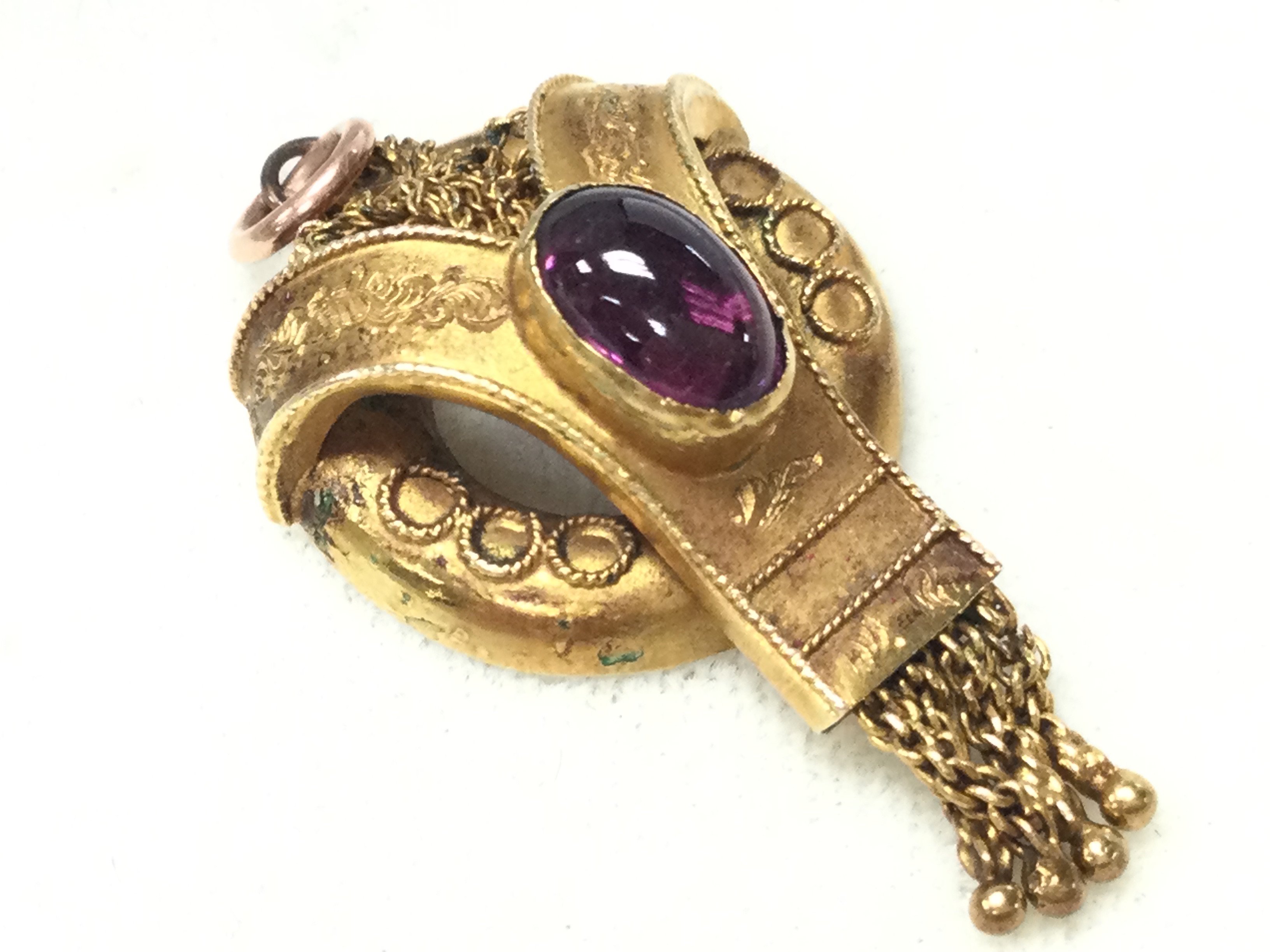 A 15ct gold Etruscan pendant set with a red Cabochon stone. Postage category A