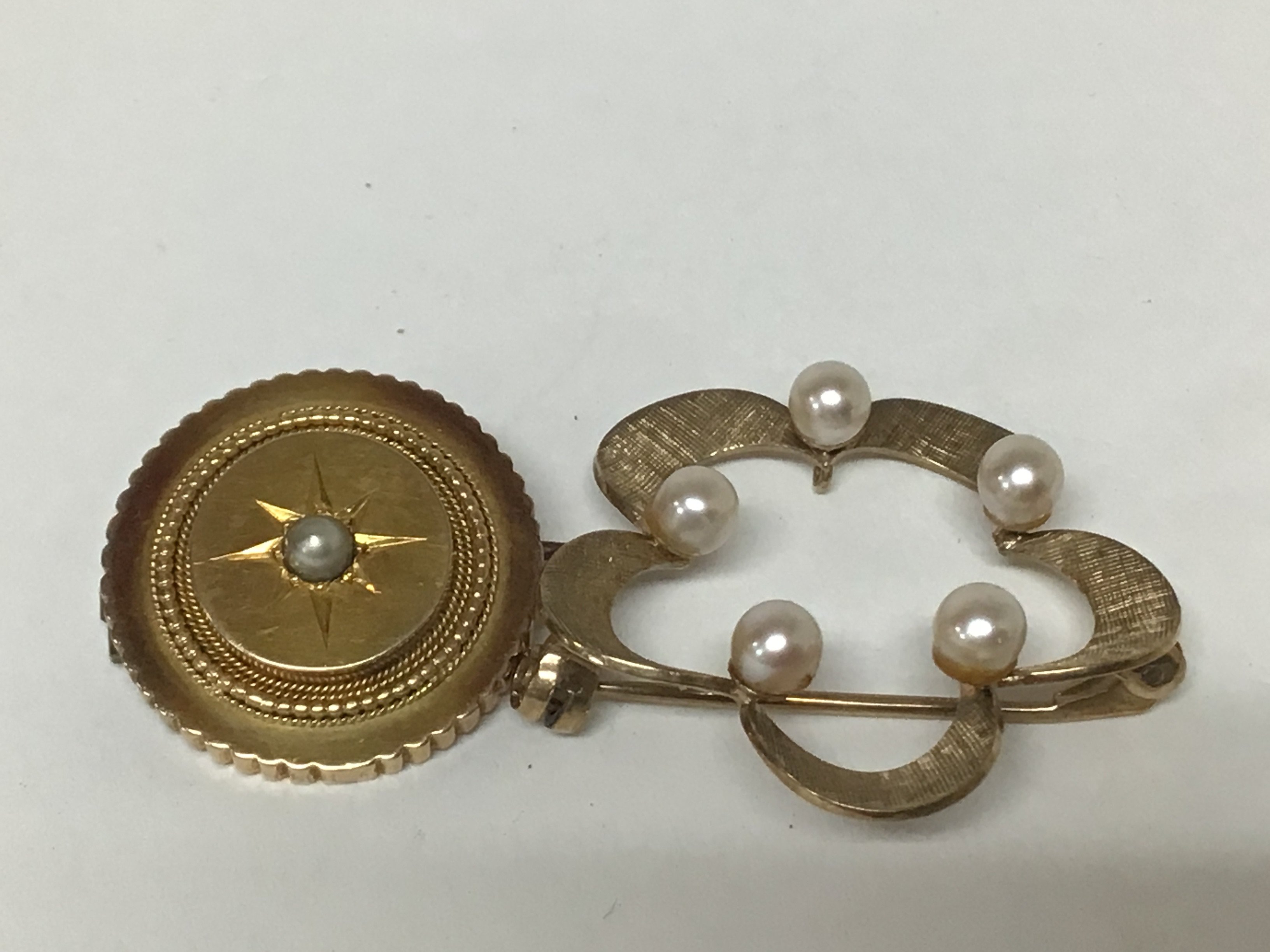 A 9carat gold open brooch set with pearls and one other brooch of circular shape set with a central pearl unmarked total weight of both brooches. 7.4g