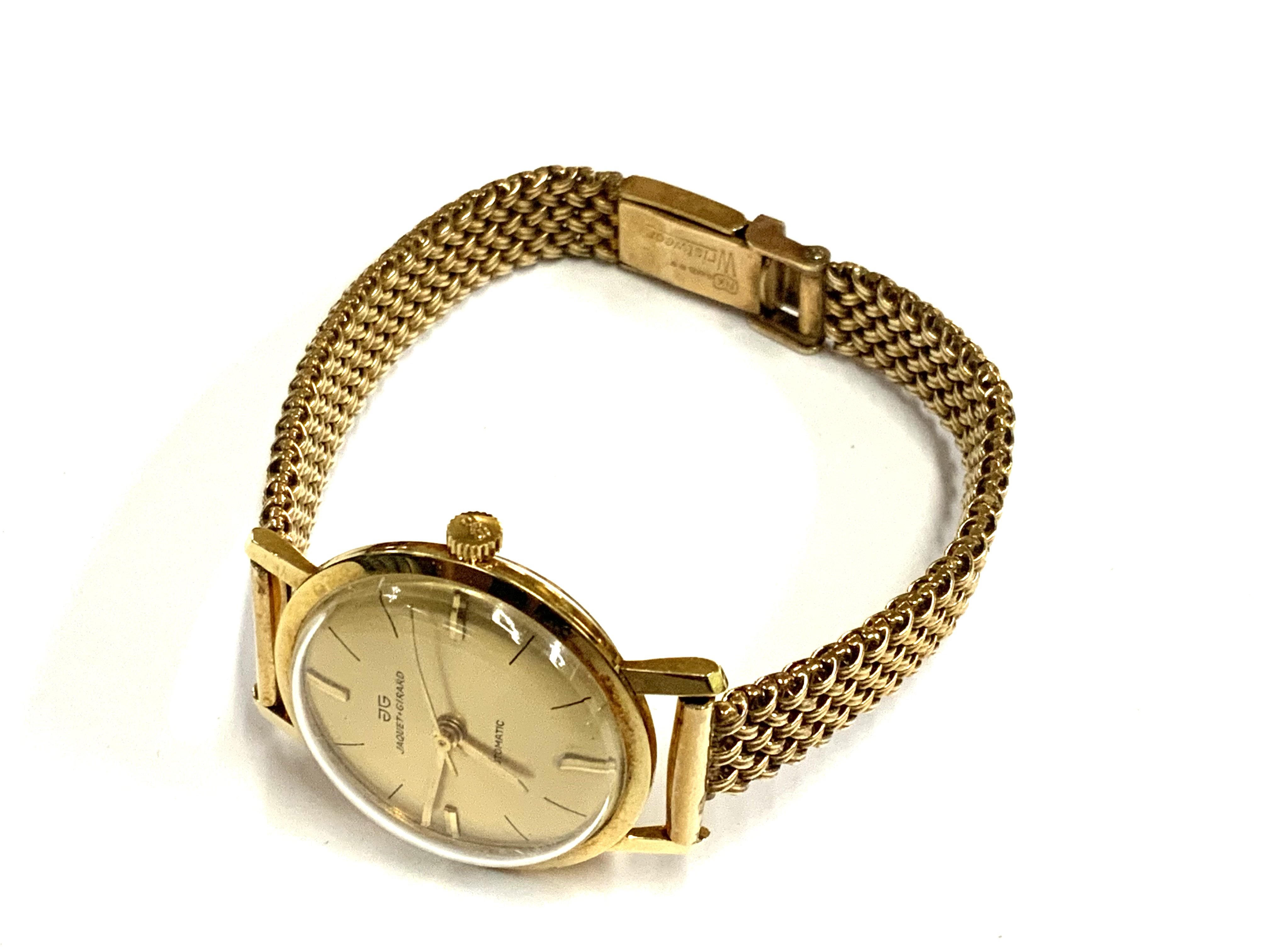 A vintage Jaquet + Girard 18ct gold cased ladies wrist watch together with a 9ct gold strap. 28.93g (A)