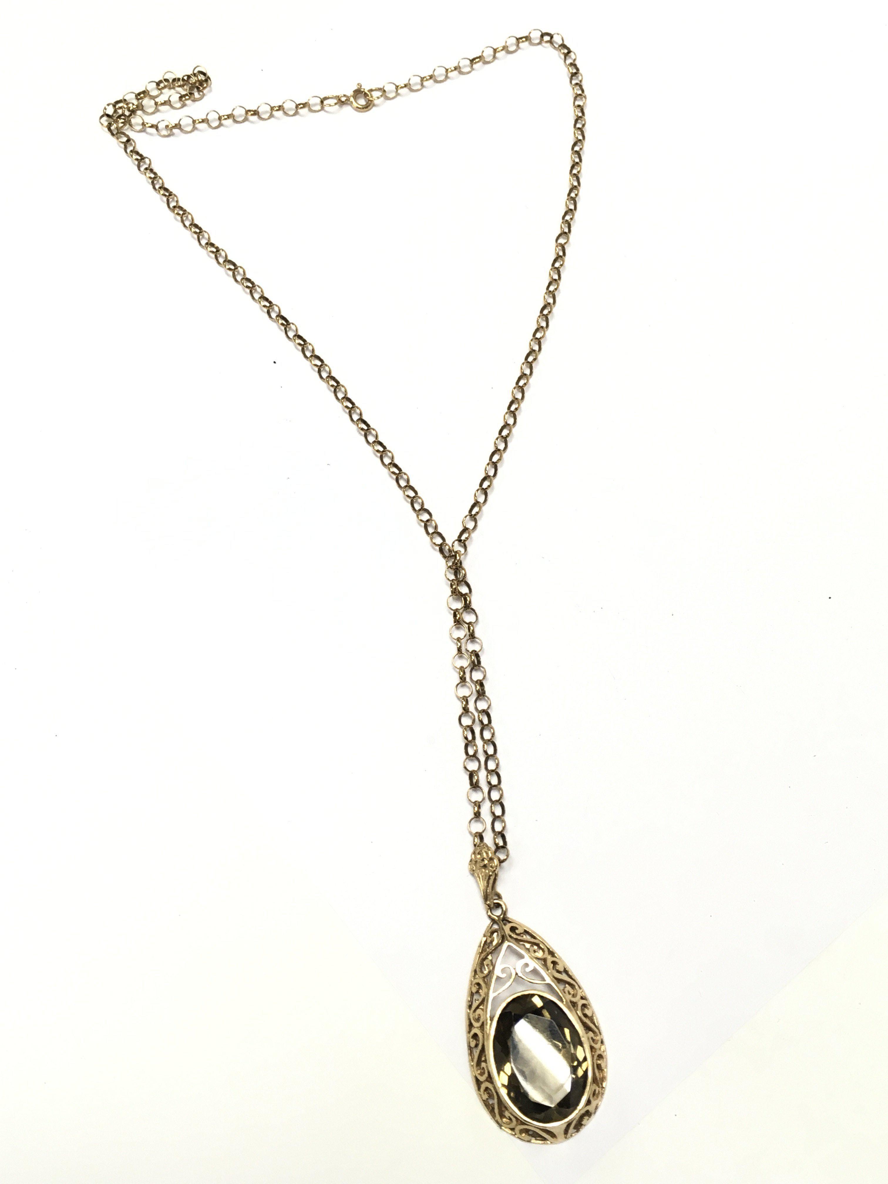 A 9 carat gold chain with a quartz stone pendant. Total weight 12.7g Postage category A