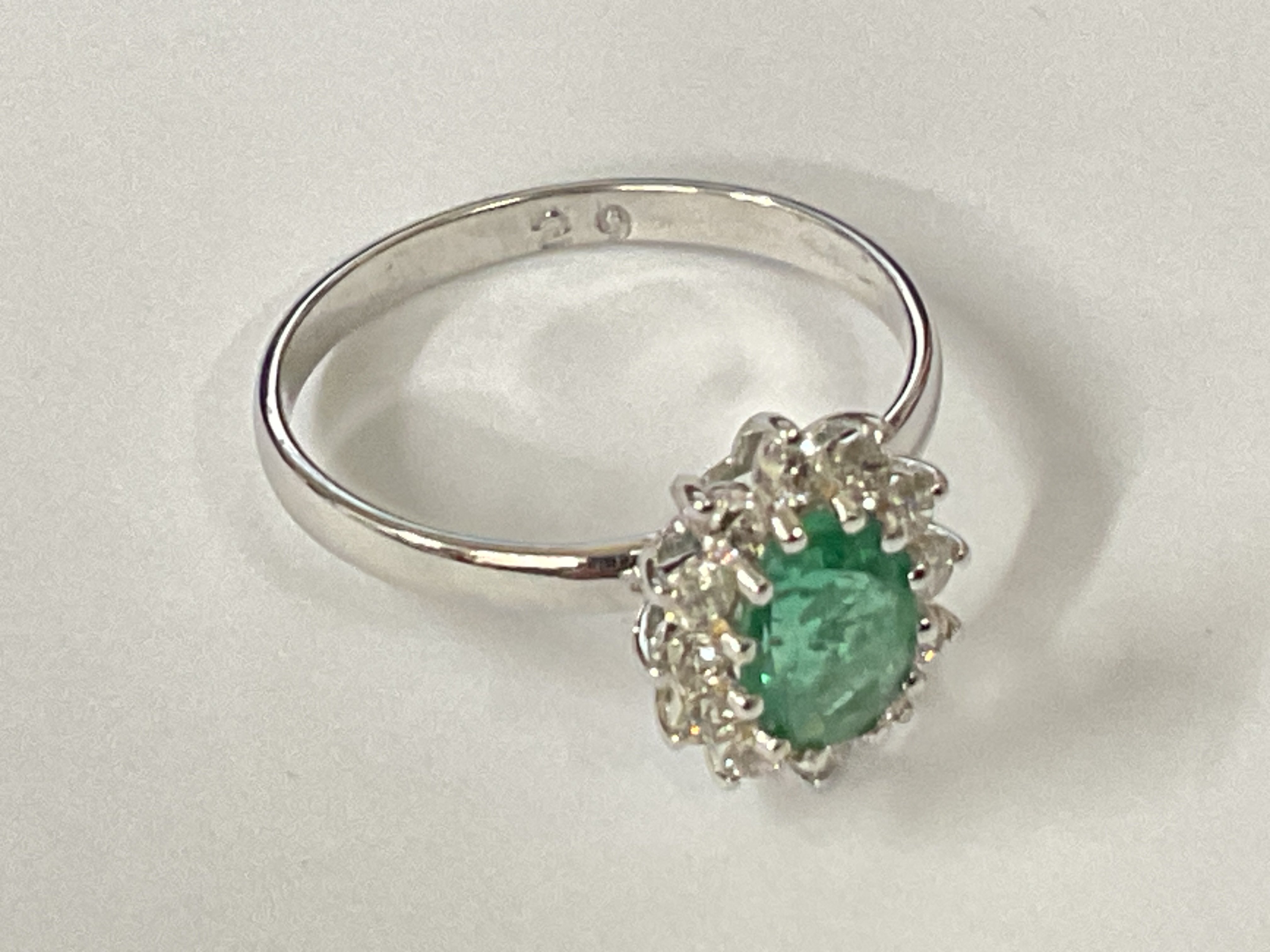 Certificated 18ct white gold oval emerald and RBC diamond cluster ring. Emerald 0.90ct. Diamonds 0.32ct. Cert no. WG19634154135. Ring size approx M/N. Postage category A.