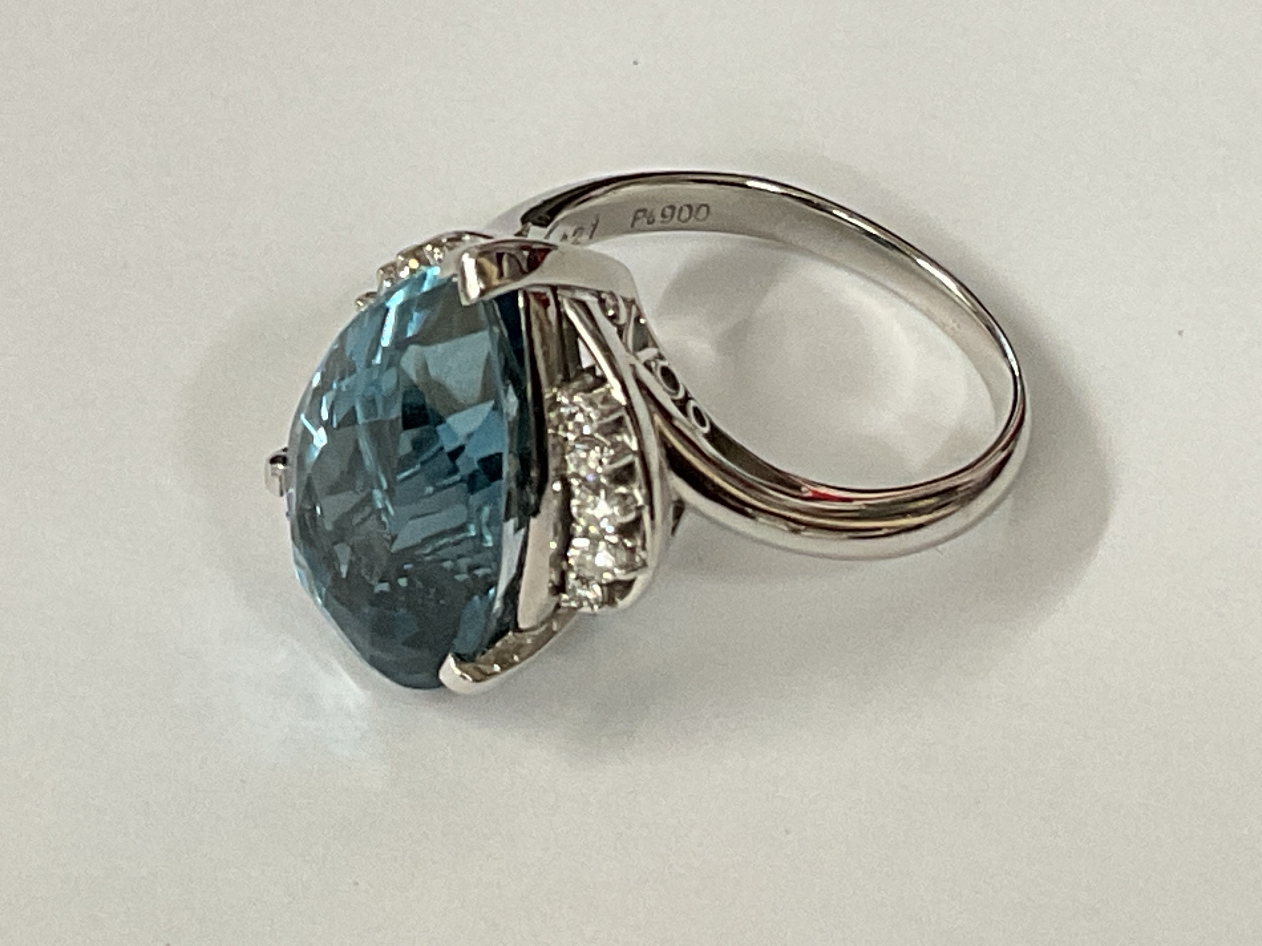 Large and weighty certificated platinum ring set with a mixed pear cut deep blue topaz and RBC diamonds. Topaz 13.72ct. Diamonds 0.28ct. Cert no. WG19624148355. Approx ring size Q/R. Postage category A.
