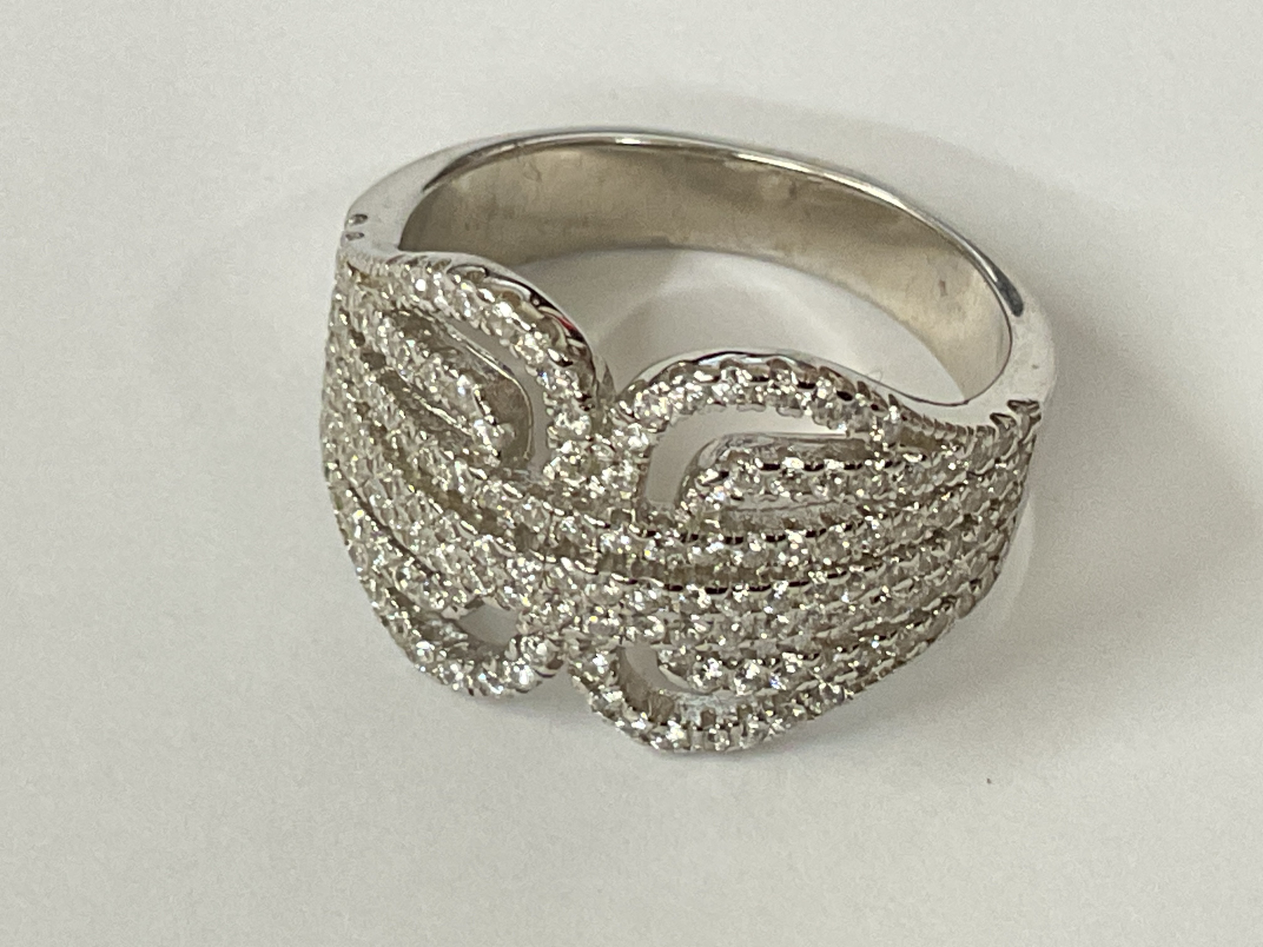 Silver belt style dress ring set with over 140 white cubic zirconia. Ring size approx O. Postage category A.