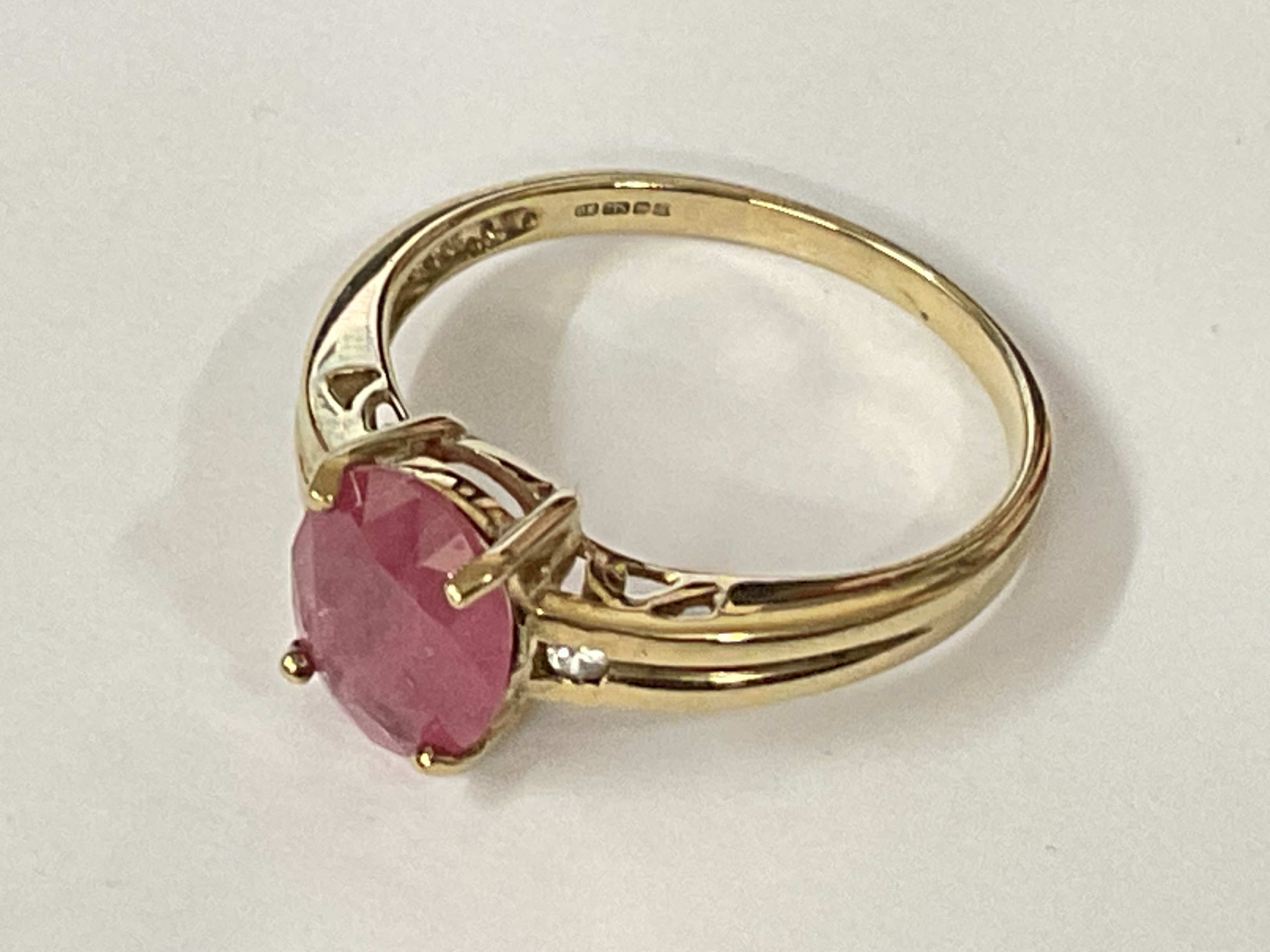 9ct yellow gold ring set with oval ruby flanked by white sapphires. Ruby 1.25ct approx. Sapphires 0.02ct approx. Ring size approx N. Postage category A.