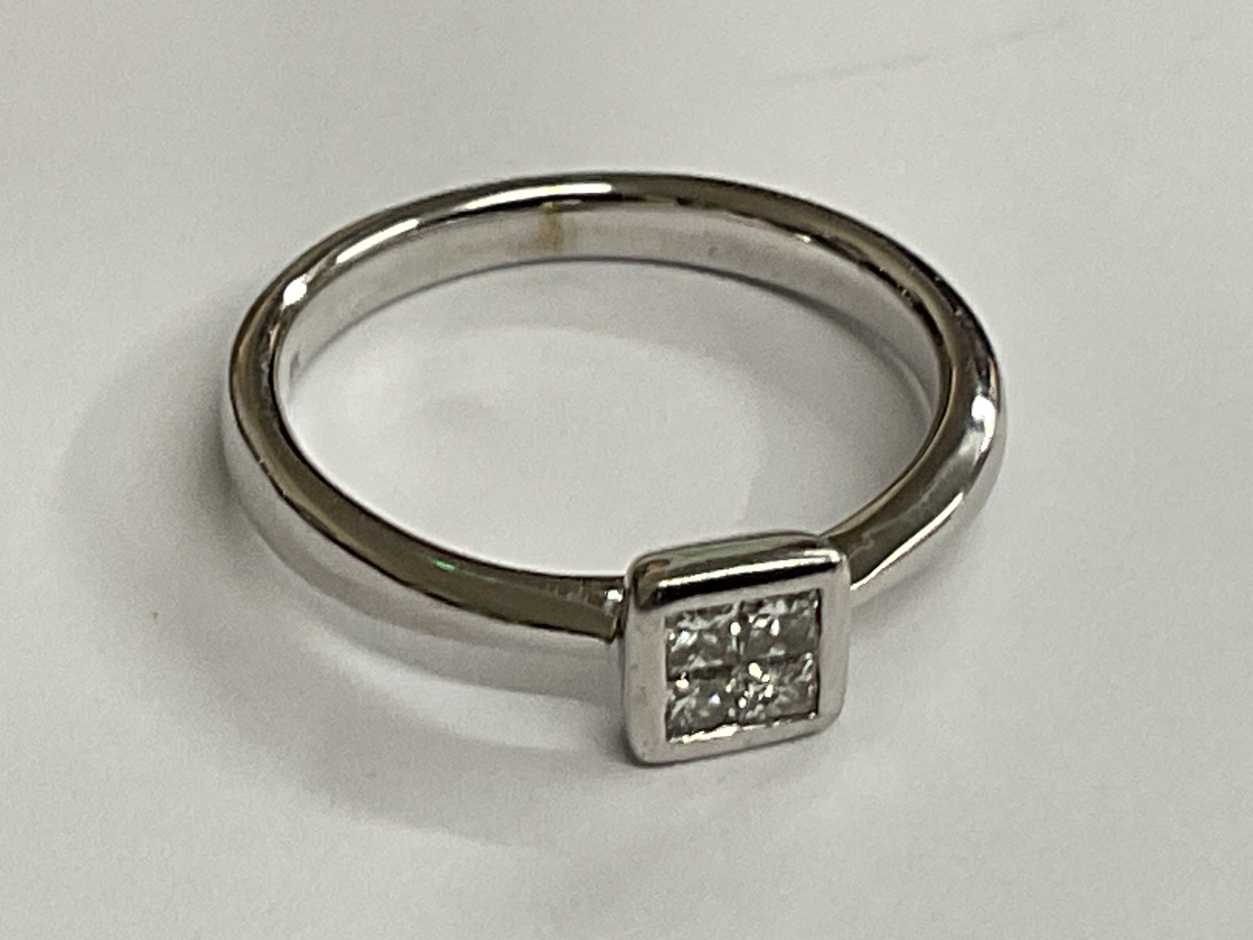 9ct white gold 4 diamond invisible set ring. Princess cut diamonds 0.32ct approx. Ring size approx L/M. Postage category A.