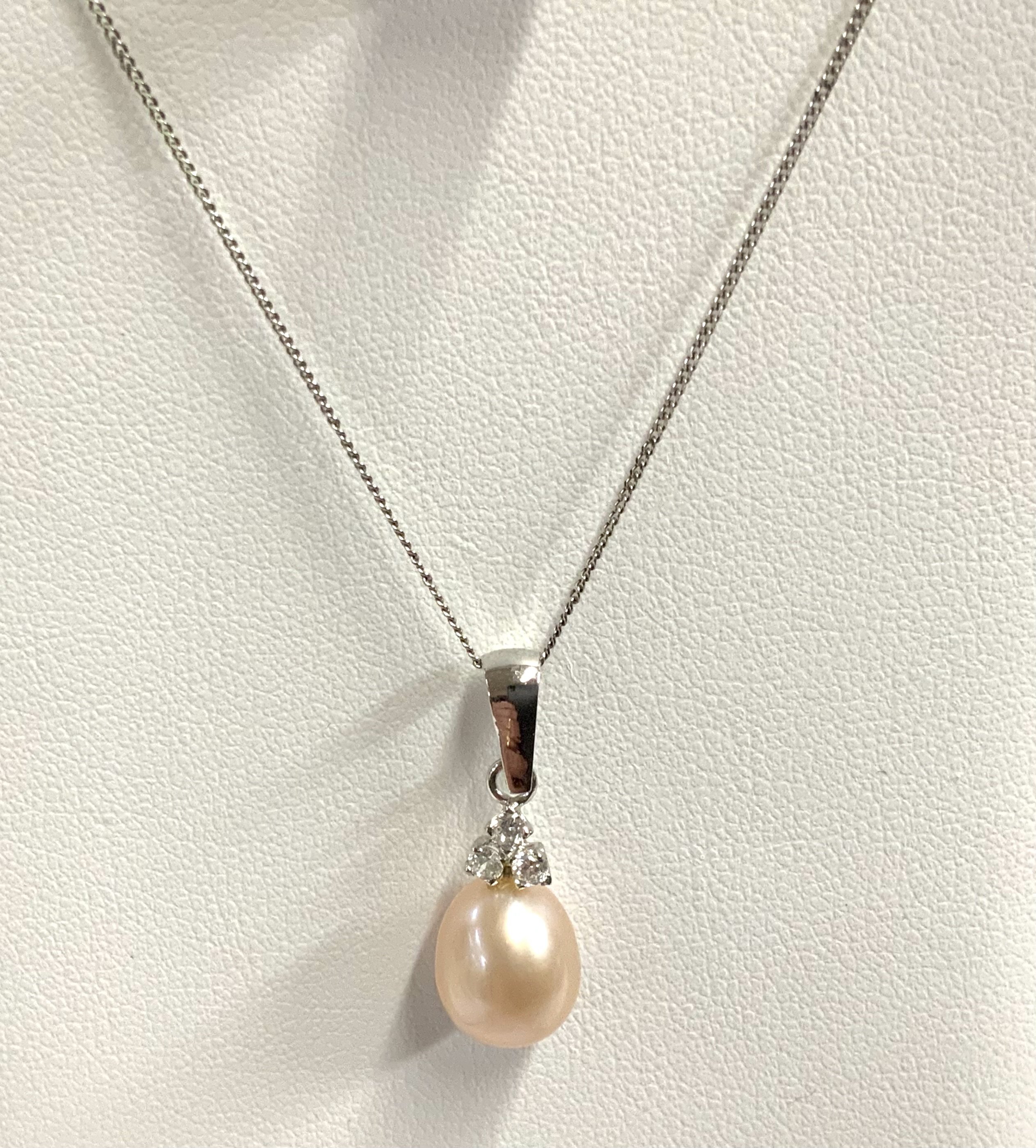 A 9ct white gold and pearl pendant and chain. (A)