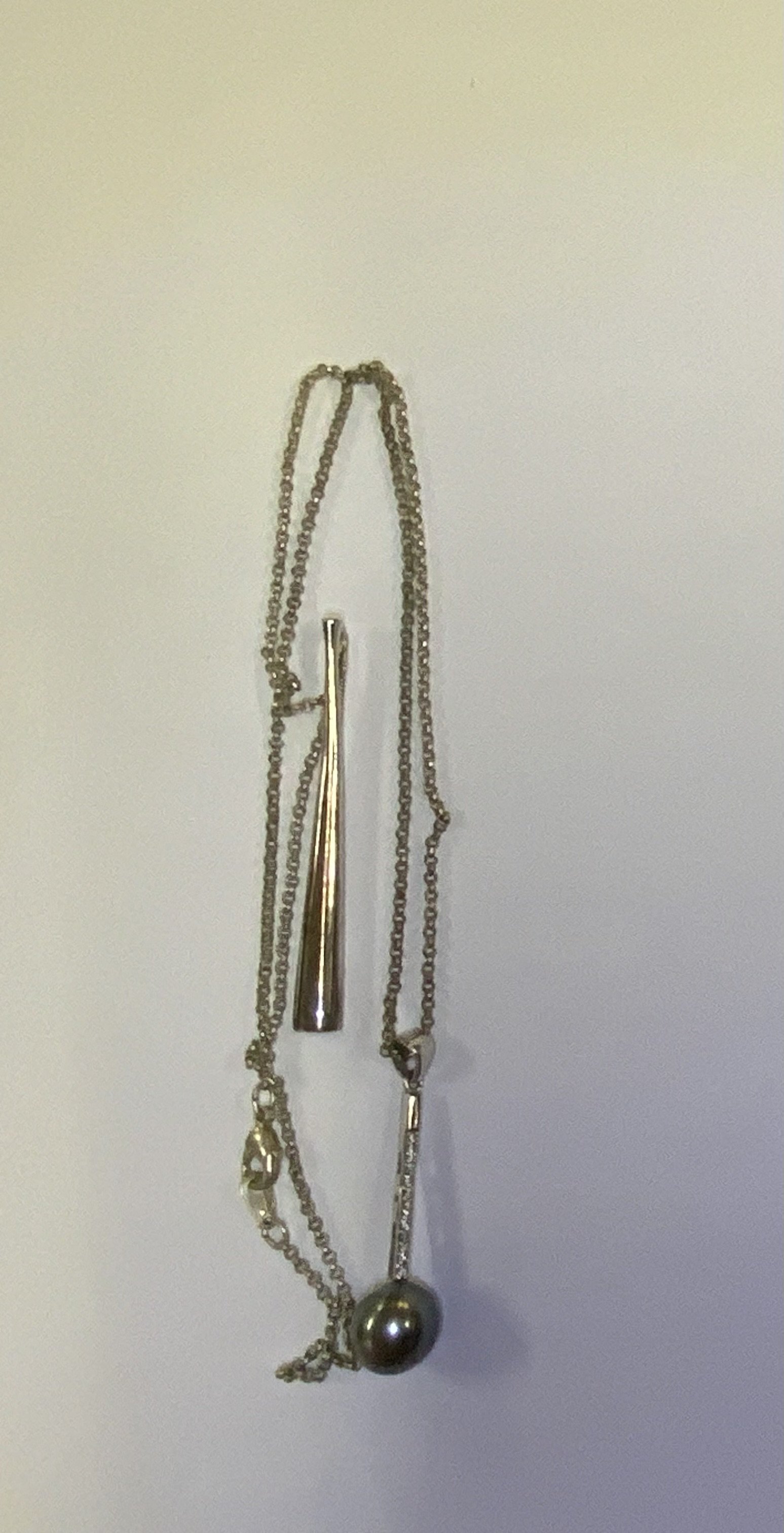 A sterling silver and black Tahitian pearl pendant together with an additional silver pendant. (A)