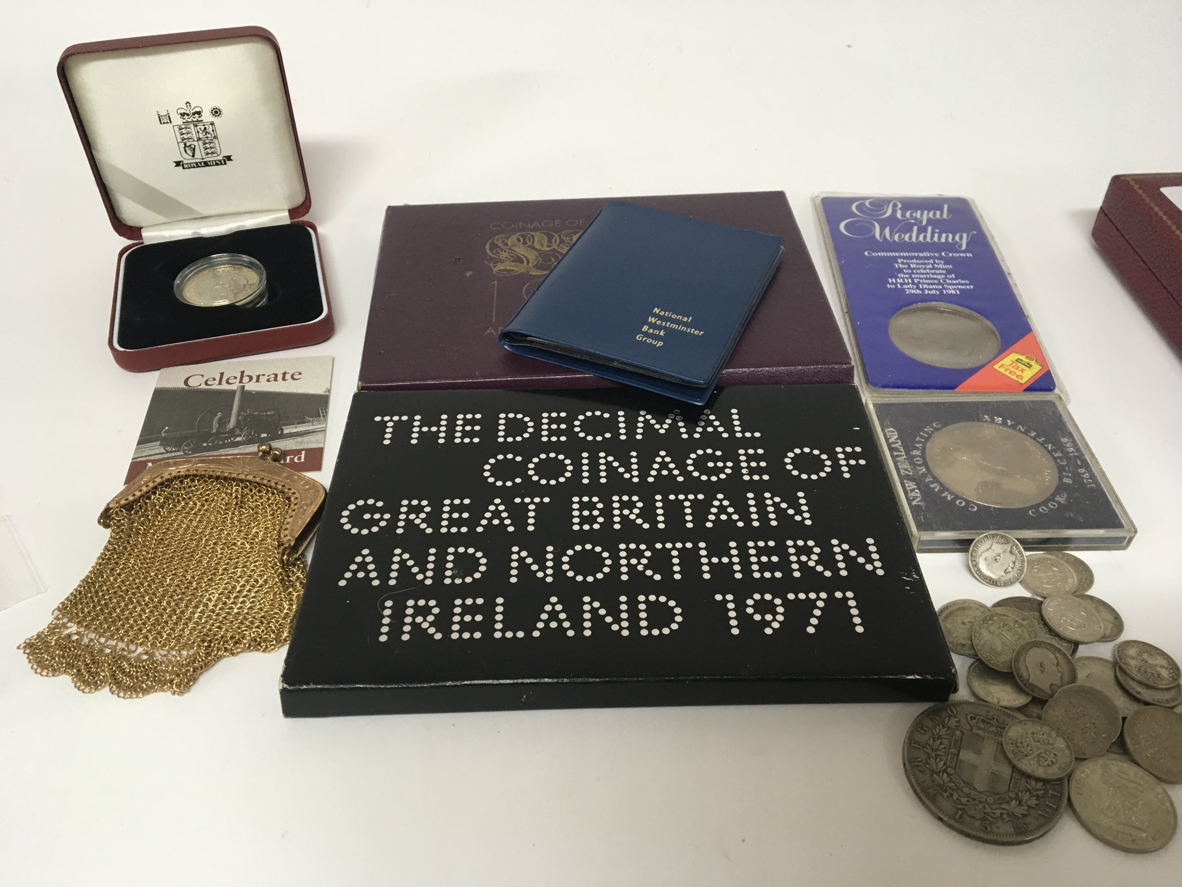 A collection of coins including 3d part silver coins a gold plated purse cased coins.