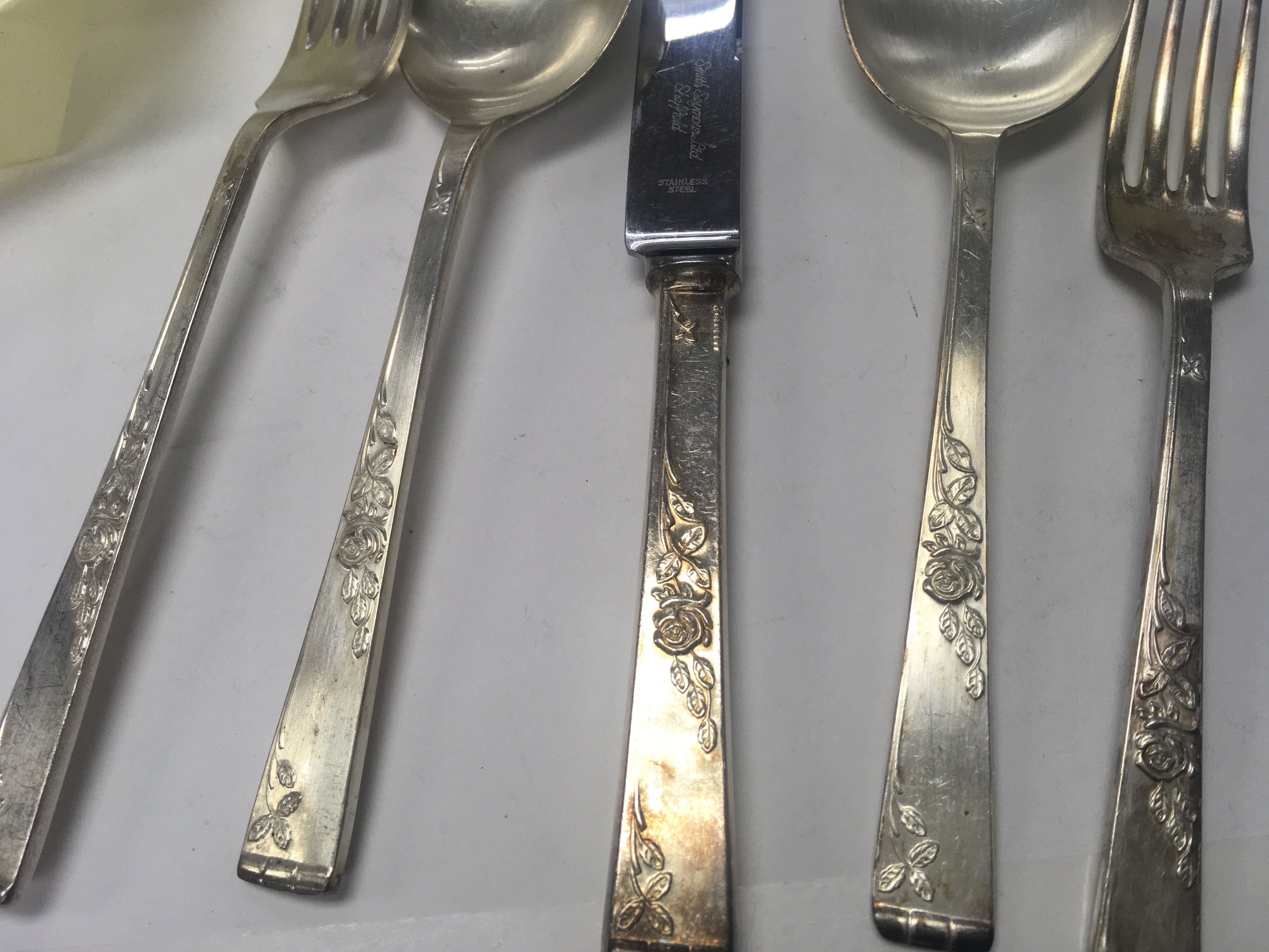 A bag containing silver plated ware various including cutlery a pair of small dishes and a cigarette case