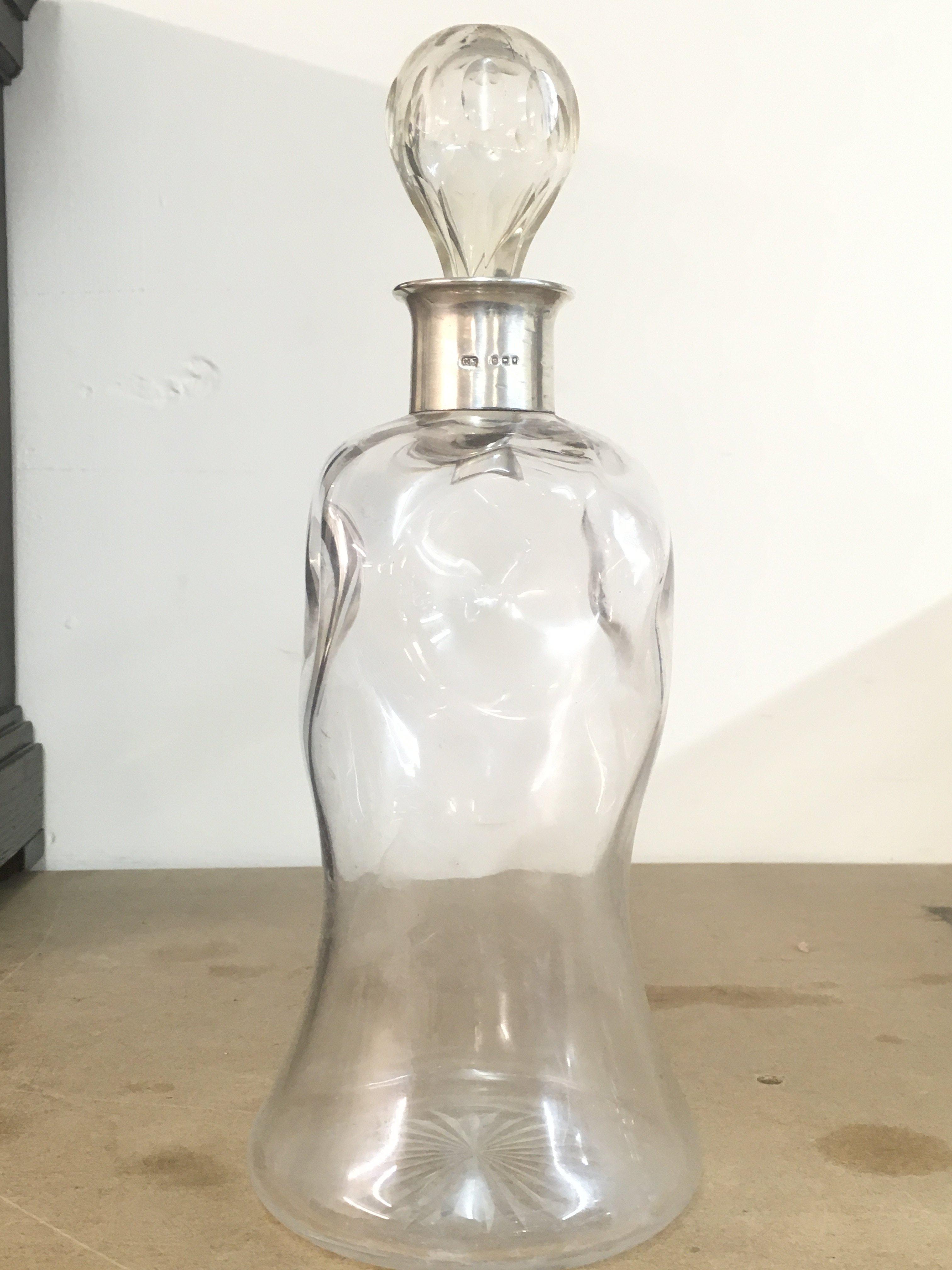A glass decanter with a hallmarked silver rim, London 1918. 28cm tall. This lot cannot be posted