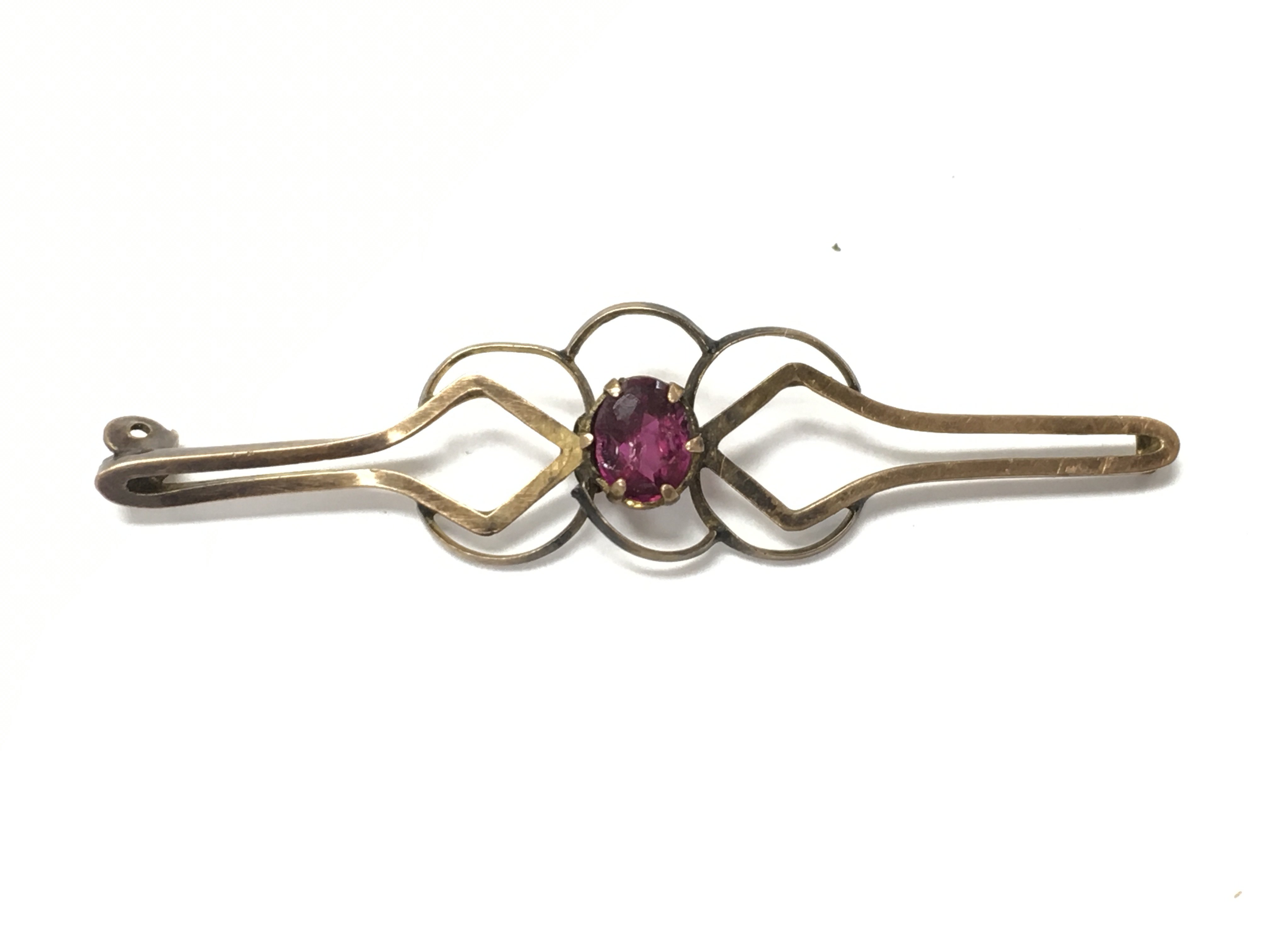 A 9ct gold brooch set with a small ruby. 1.60g