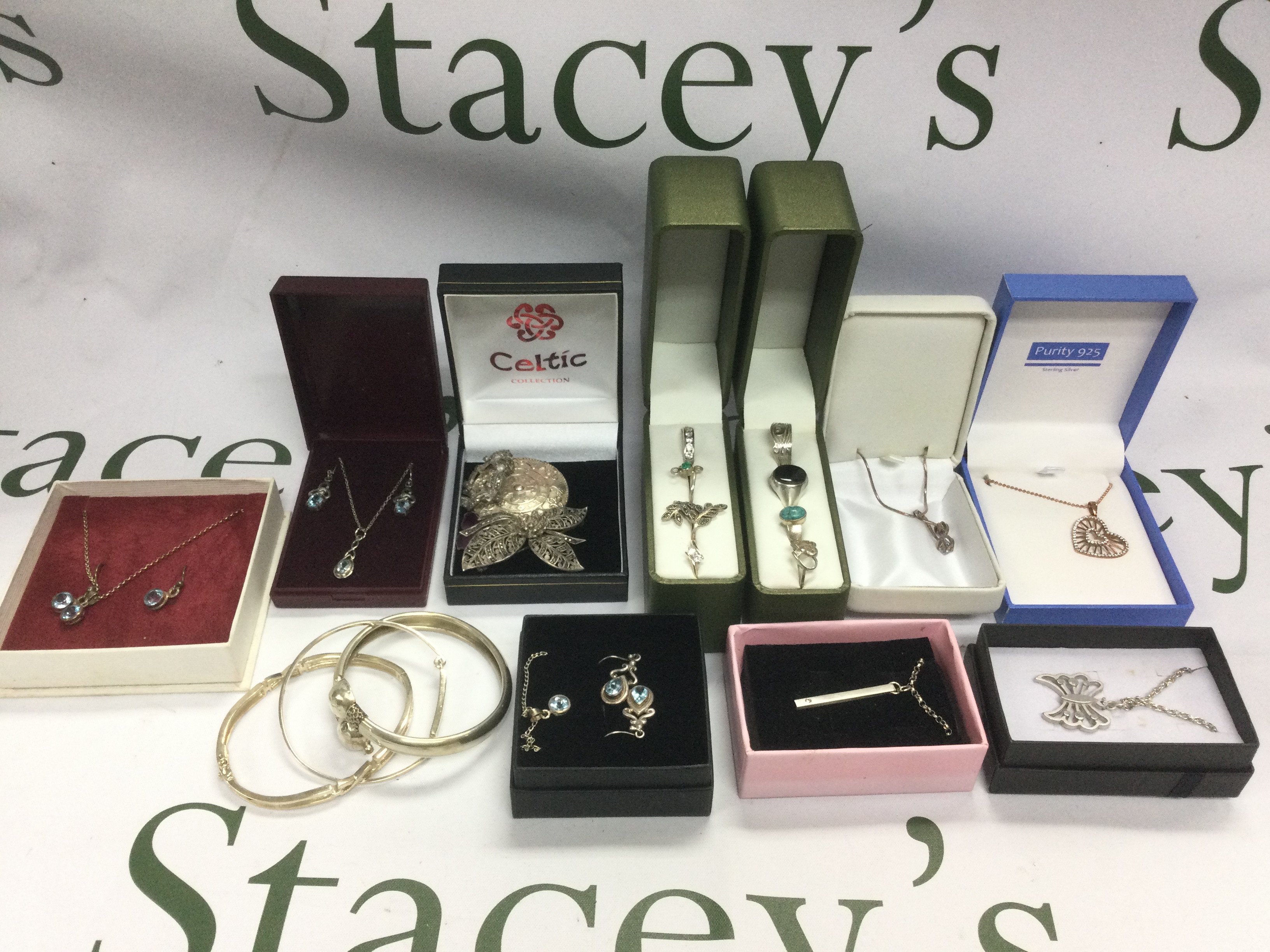 A tin of silver and costume jewellery comprising rings, bangles, necklaces, earrings etc.