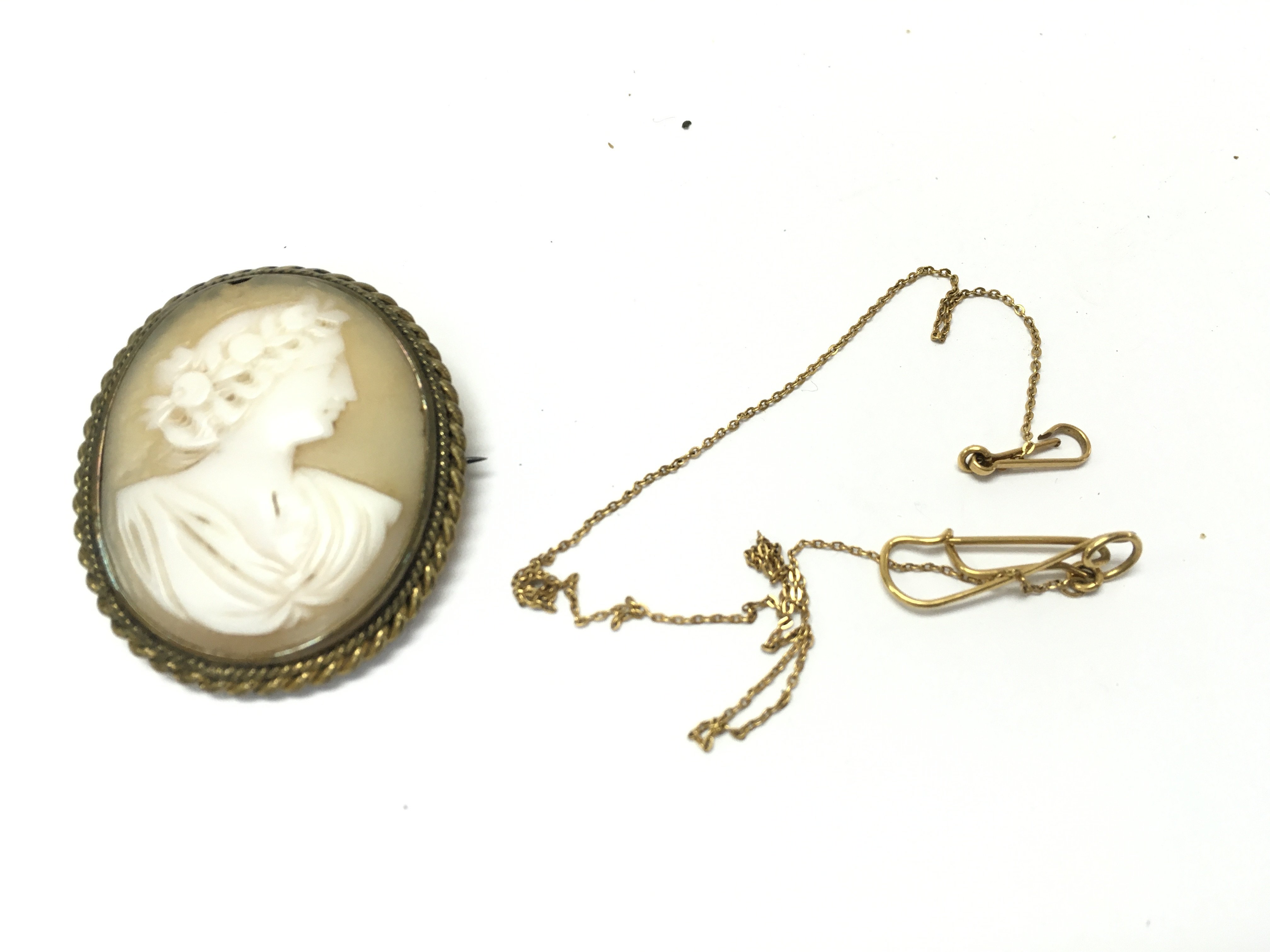 An unmarked yellow metal fine chain and a cameo brooch. Postage A